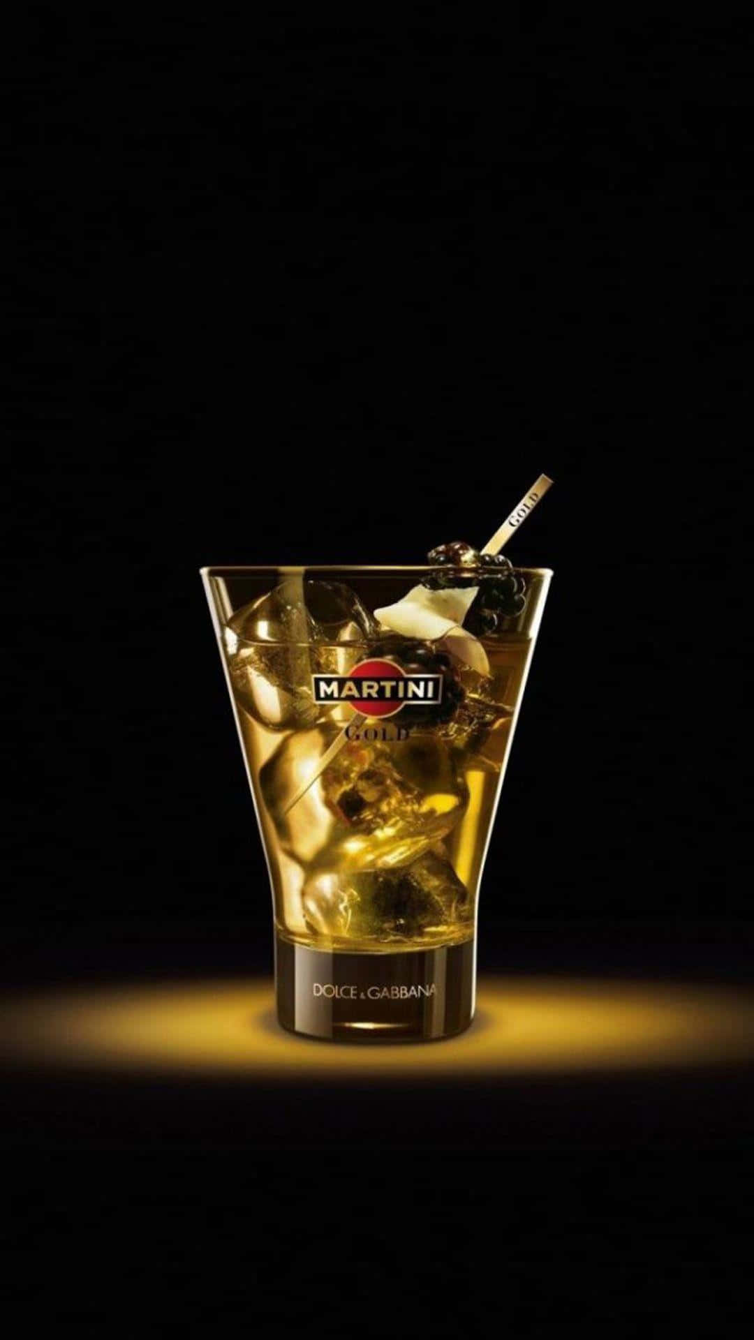alcohol 桌布 壁紙 — 一杯閃耀金色光芒的馬丁尼雞尾酒，配有冰塊、橄欖和品牌攪拌棒，置於黑色背景中央。