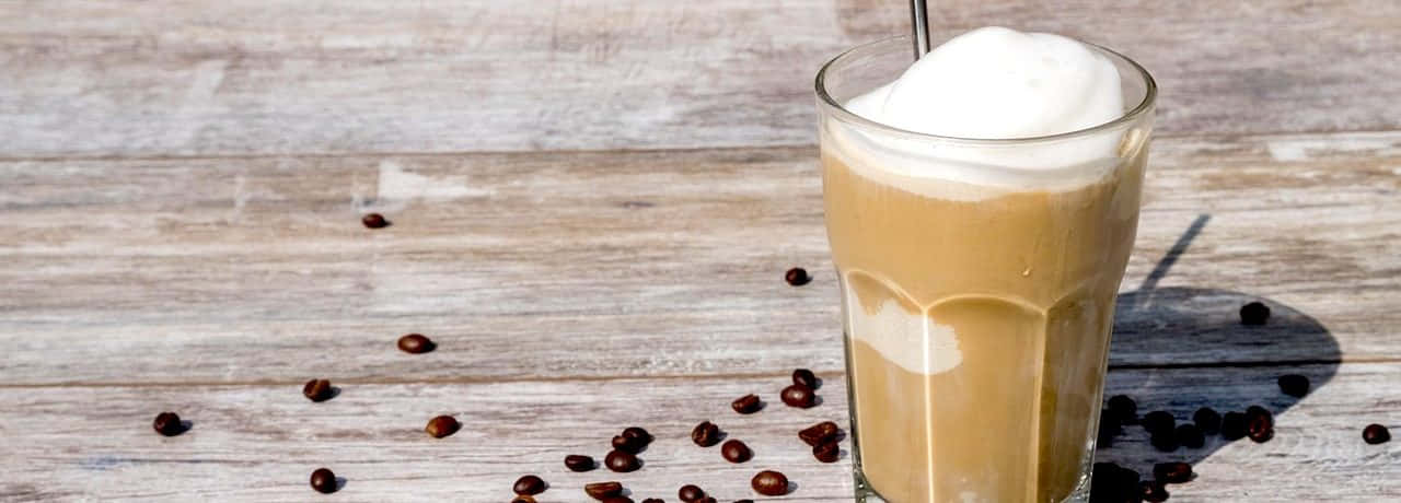 Milk And Coffee 桌布 壁紙 — 一杯高身忌廉冰咖啡，上面有忌廉，咖啡豆散落在經風化的木質表面上。