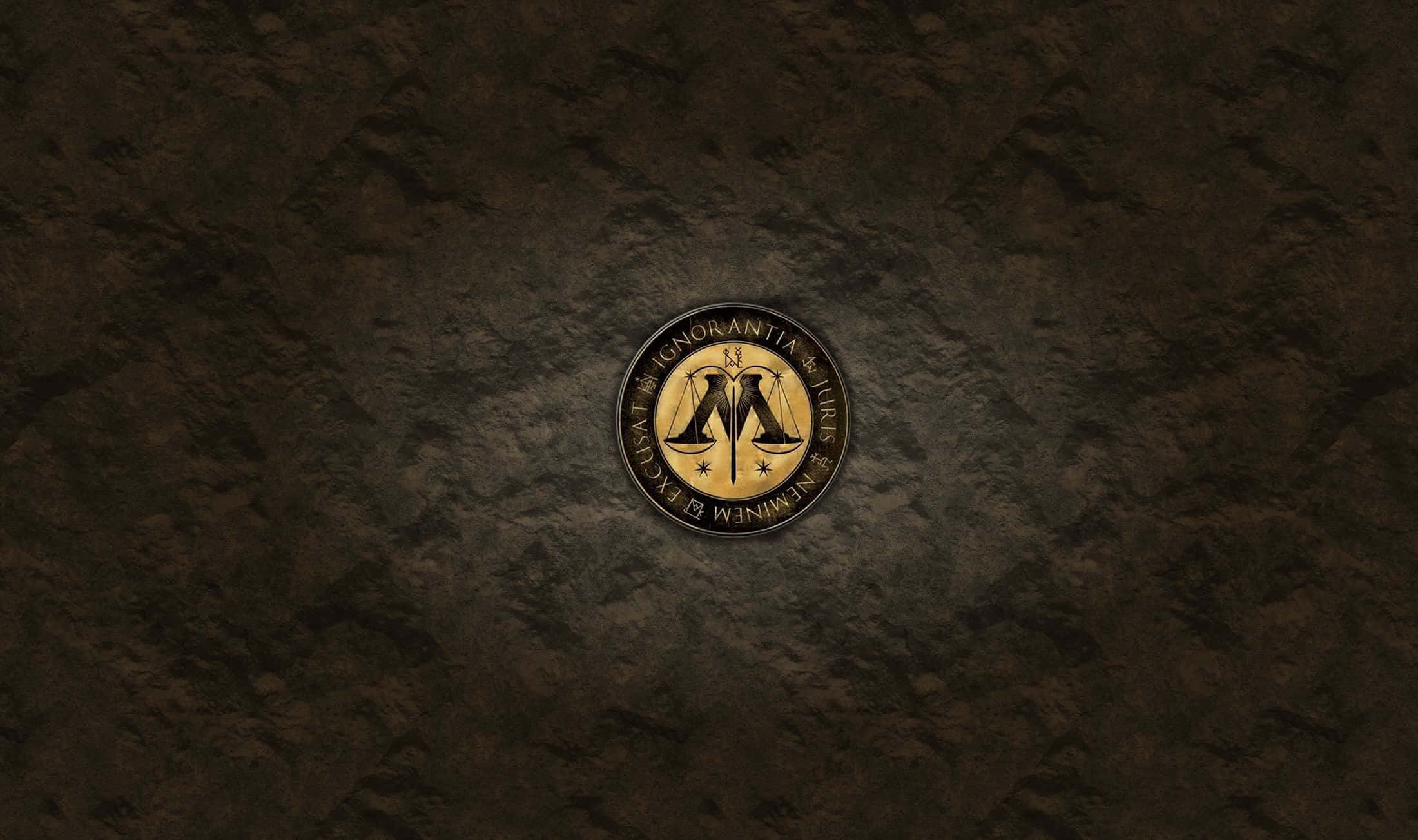 The Ministry Of Magic 桌布 壁紙 — 一枚帶有正義天秤和拉丁文字的金幣，居中放置在深色紋理石面上。