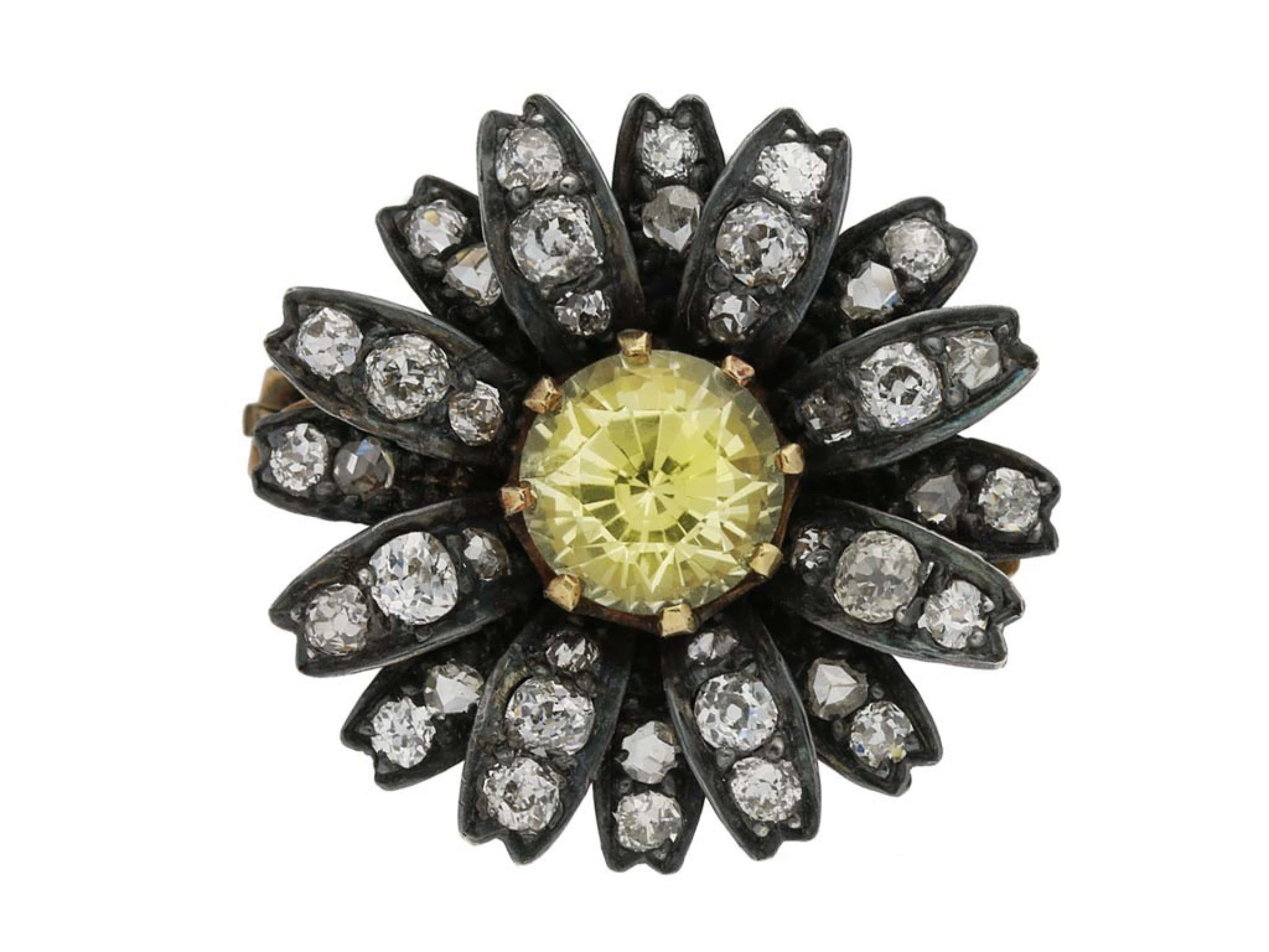 Yellow Sapphire 桌布 壁紙 — 一枚復古戒指，中央鑲嵌一顆璀璨的黃色主石，周圍環繞著鑲有閃亮鑽石的黑色花瓣。