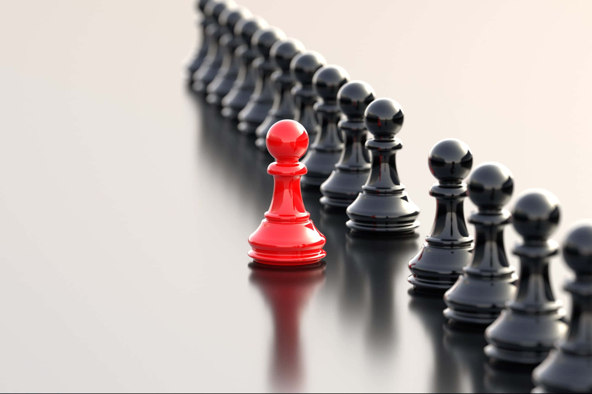 一枚紅色棋子在眾多黑色棋子中顯眼 壁紙 — 一個紅色棋子在反光表面上從一排黑色棋子中脫穎而出。