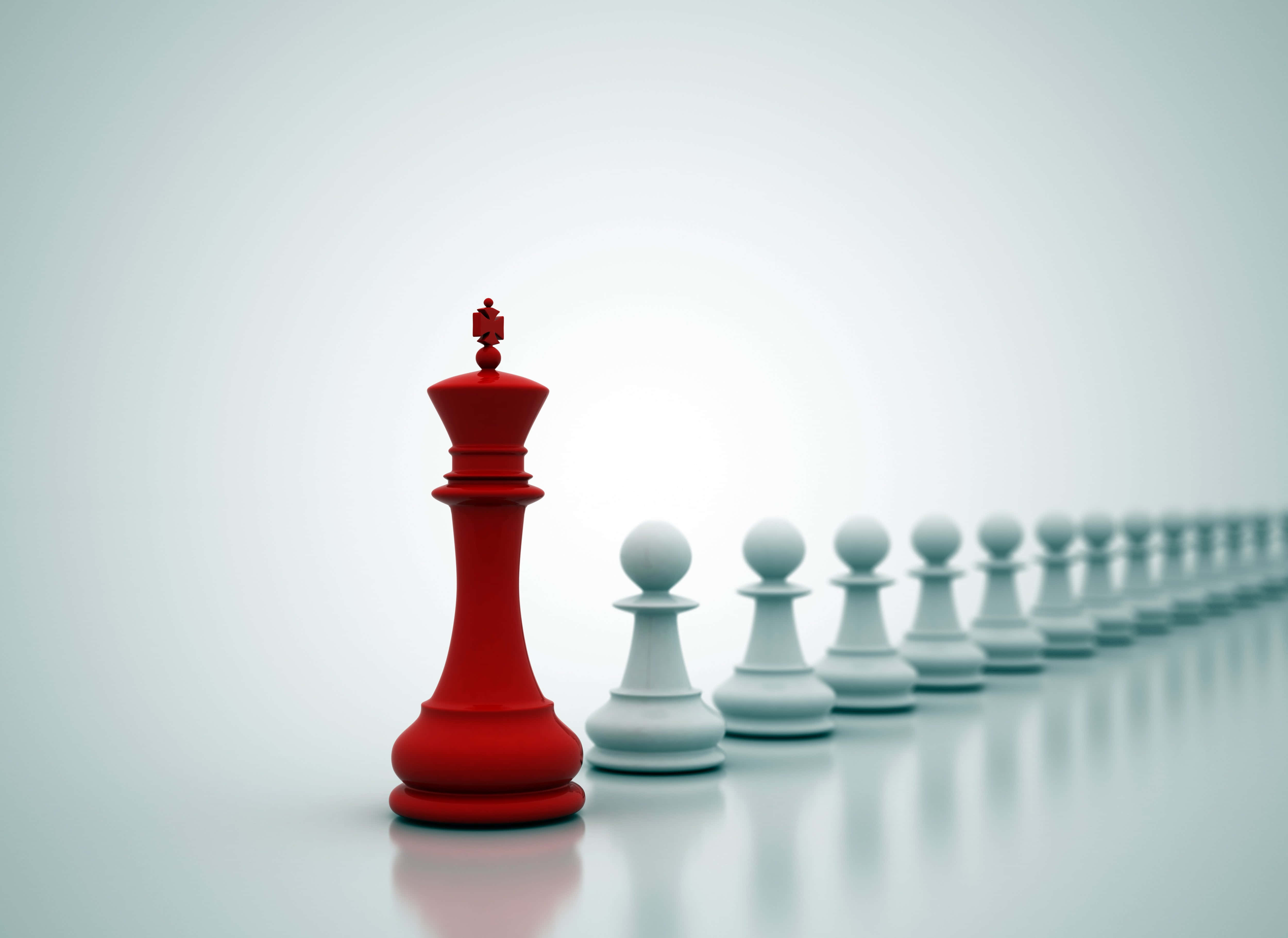 一枚紅色棋子立於一排白色棋子中央 壁紙 — 一個大膽的紅色國王獨自面對一排白色兵卒，立於極簡風格的反射表面上。