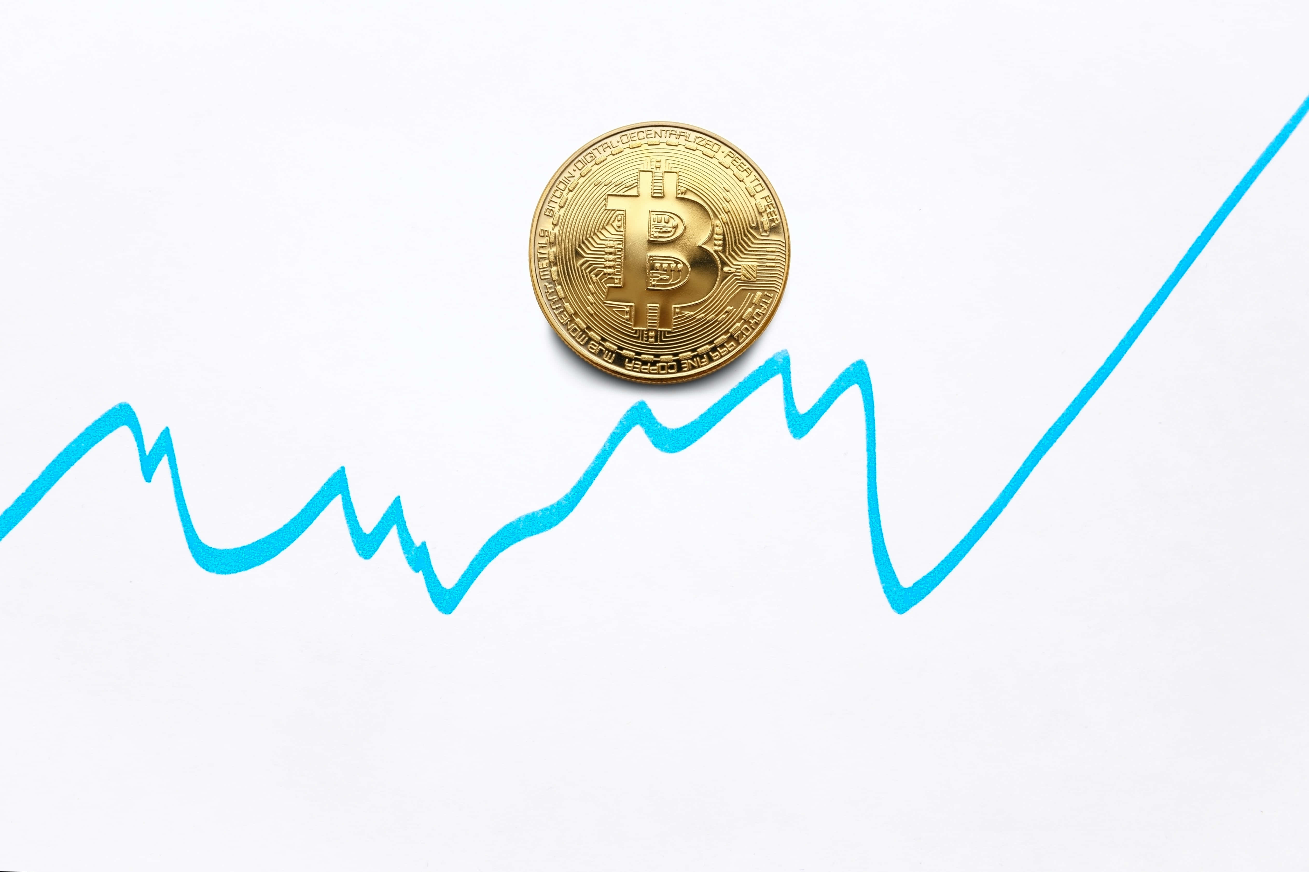 Mining 桌布 壁紙 — 一枚金色比特幣硬幣放在白色背景上的藍色上升趨勢線圖上。