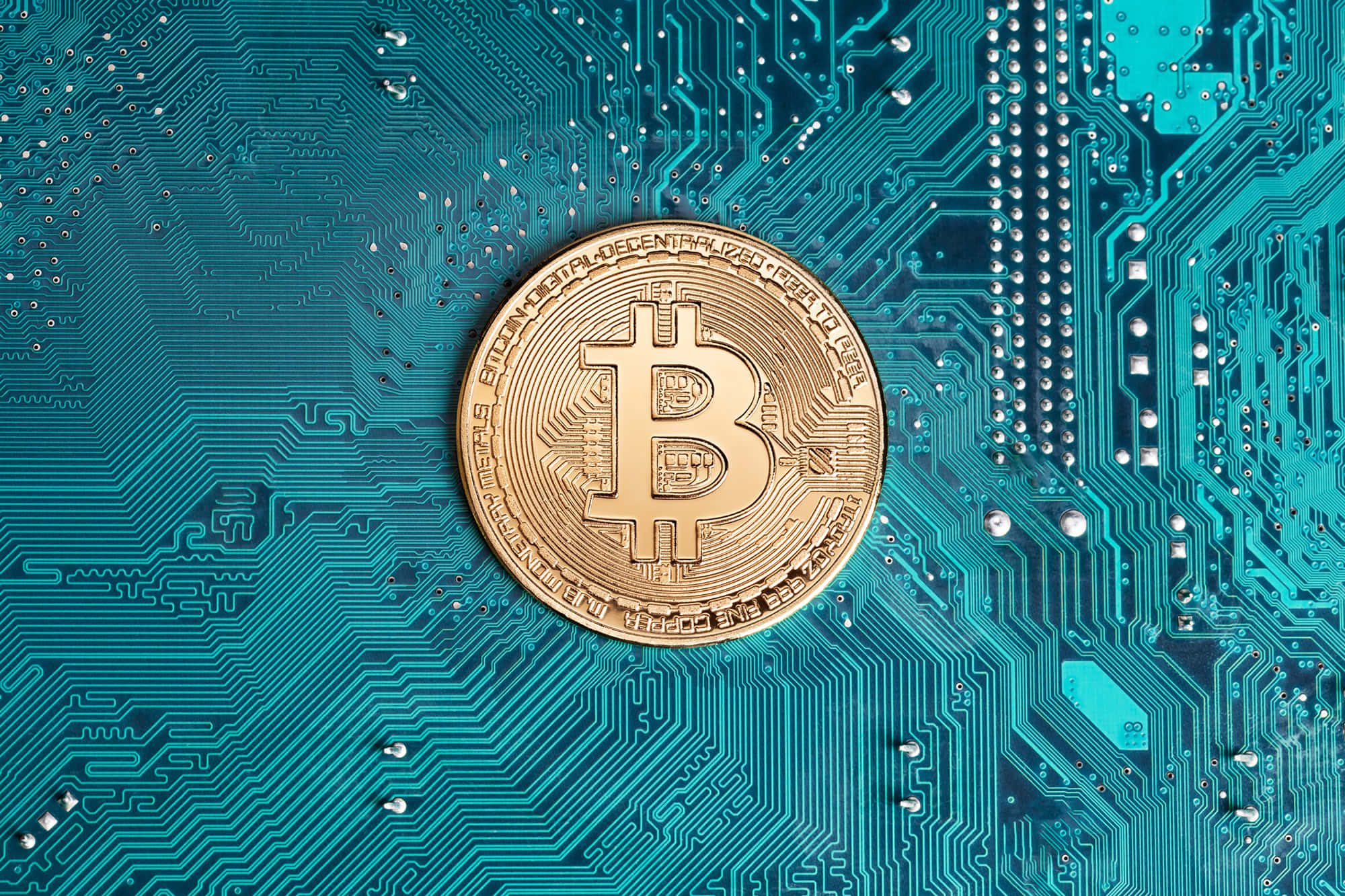 加密貨幣 桌布 壁紙 — 一枚金色比特幣硬幣放在青綠色電路板上，突顯數碼金融和加密貨幣技術。