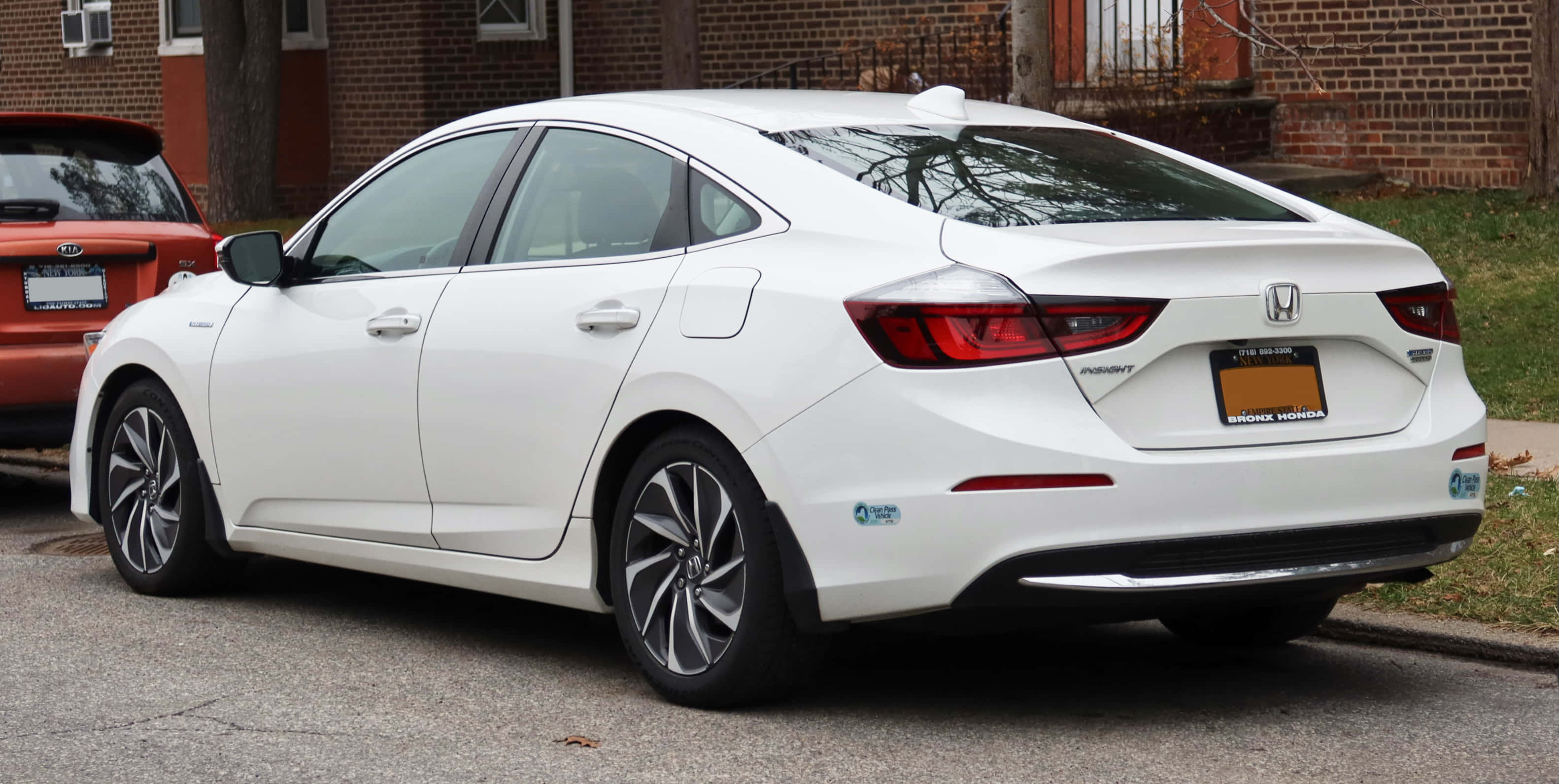 Honda Insight 桌布 壁紙 — 一架乾淨的白色本田Insight混合動力轎車停泊在磚屋旁邊的住宅街道上。