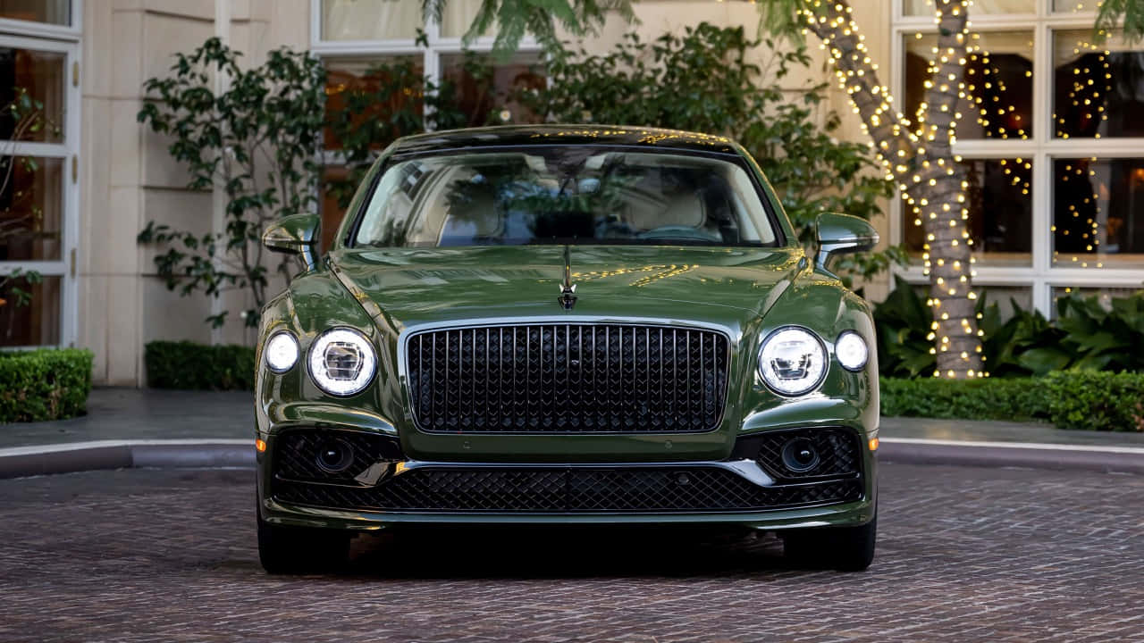 Bentley Flying Spur 桌布 壁紙 — 一架亮綠色賓利Bentayga停在鵝卵石車道上，後面樹上掛著節日燈串。