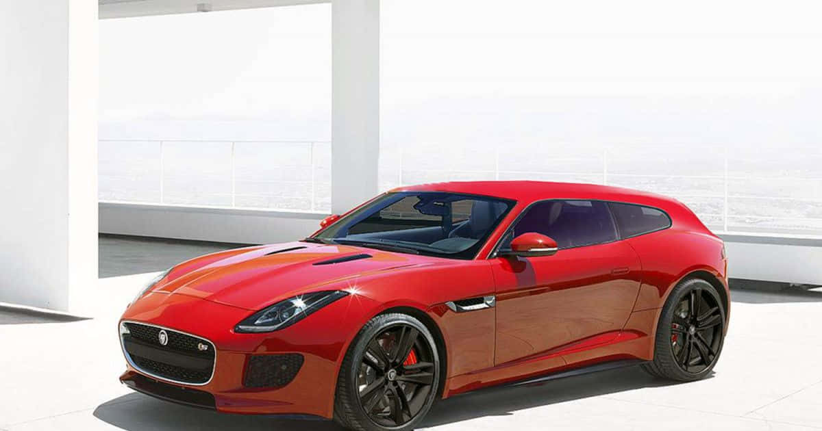 Hatchback 桌布 壁紙 — 一架亮麗的紅色Jaguar F-Type跑車停泊在簡約的白色露台上，俯瞰著朦朧的遠方城市景觀。