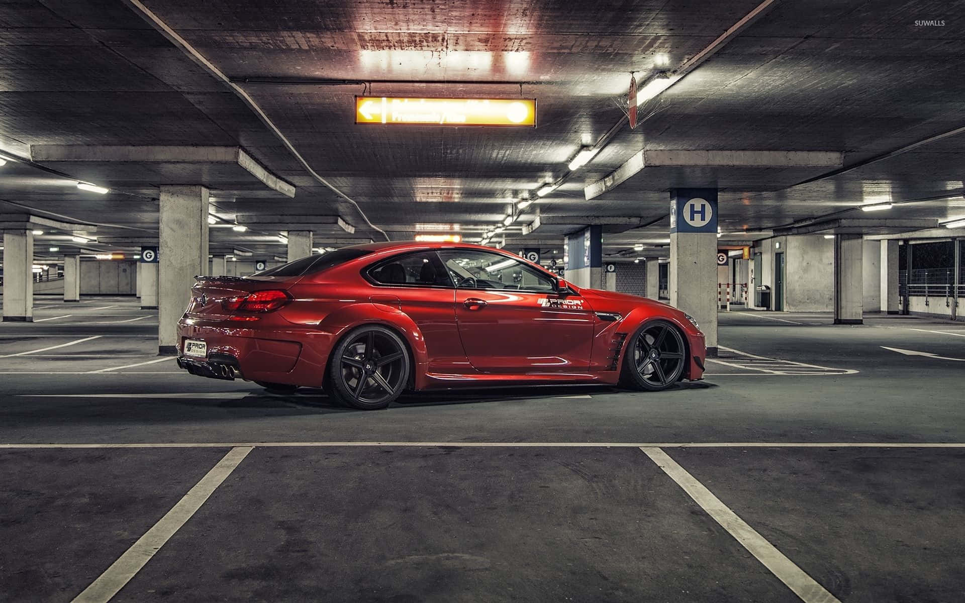 Bmw 6 Series 桌布 壁紙 — 一架亮麗的紅色跑車停泊在燈光昏暗的地下停車場，內有混凝土柱和天花燈。