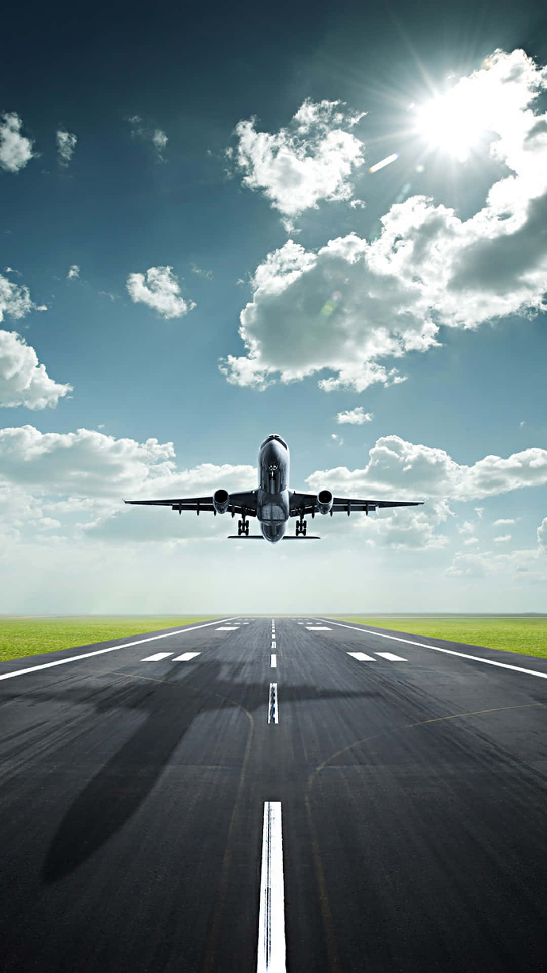 一架優雅飛機穿雲而過 壁紙 — 一架商用飛機在明亮的陽光和散落的雲朵下從跑道上升起。