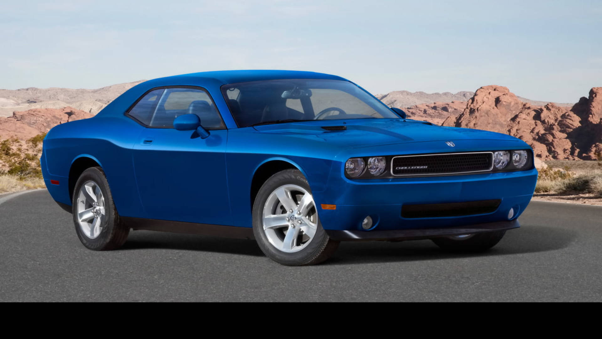 dodge challenger 桌布 壁紙 — 一架充滿活力的藍色 Dodge Challenger 肌肉車停泊在沙漠公路上，背景是紅色岩石地貌。