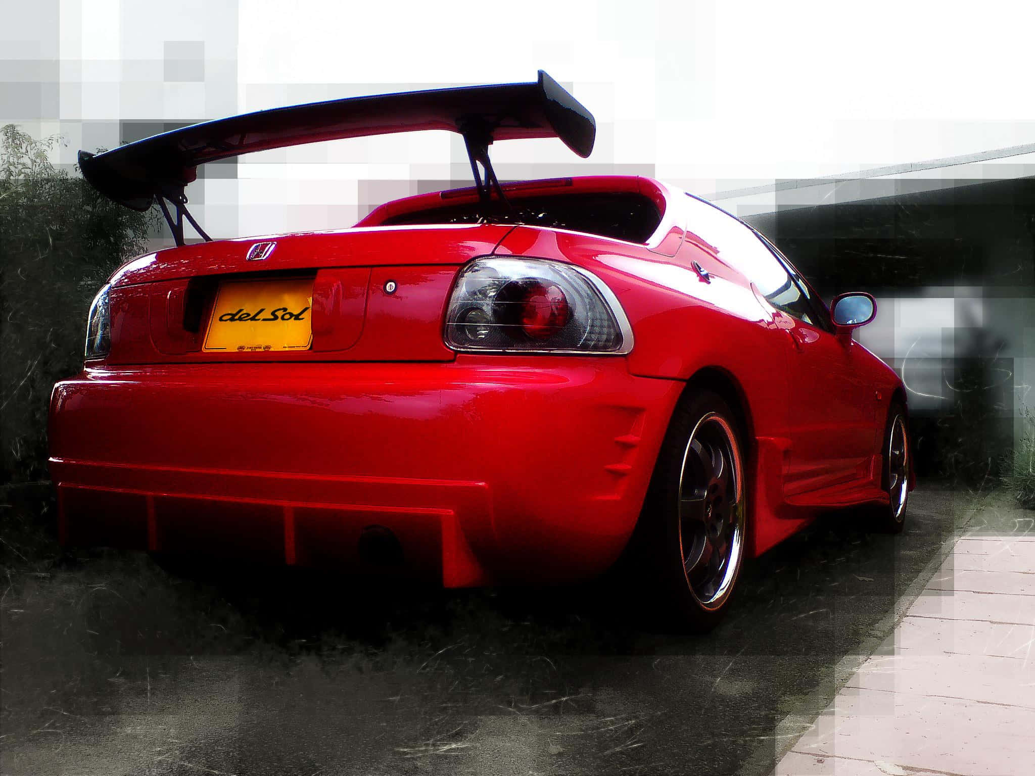 Honda Civic Del Sol 桌布 壁紙 — 一架光澤的紅色本田 Del Sol 跑車，帶有大型後擾流板，停放在潮濕的路面上，天空多雲。