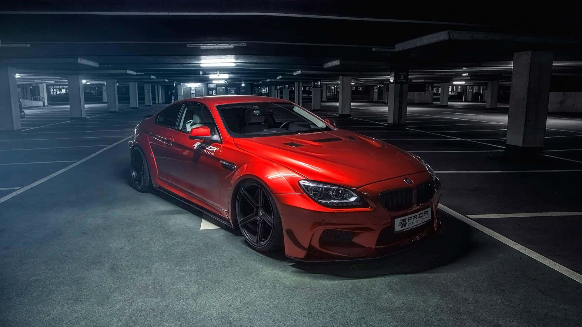 Bmw 6 Series 桌布 壁紙 — 一架光澤紅色BMW M6跑車獨自停泊在燈光昏暗、天花燈光刺眼的地下停車場。