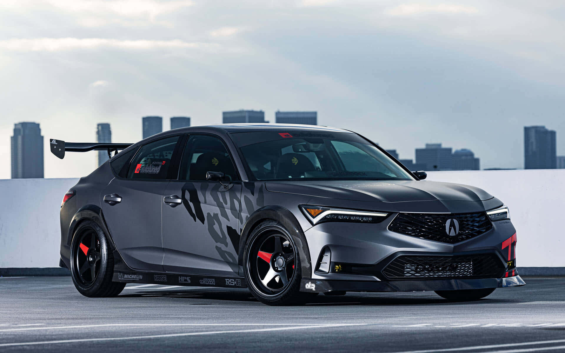 Acura Integra 桌布 壁紙 — 一架啞光灰色Acura NSX賽車，帶有紅色點綴和大型後擾流板，停泊在俯瞰城市天際線的屋頂上。