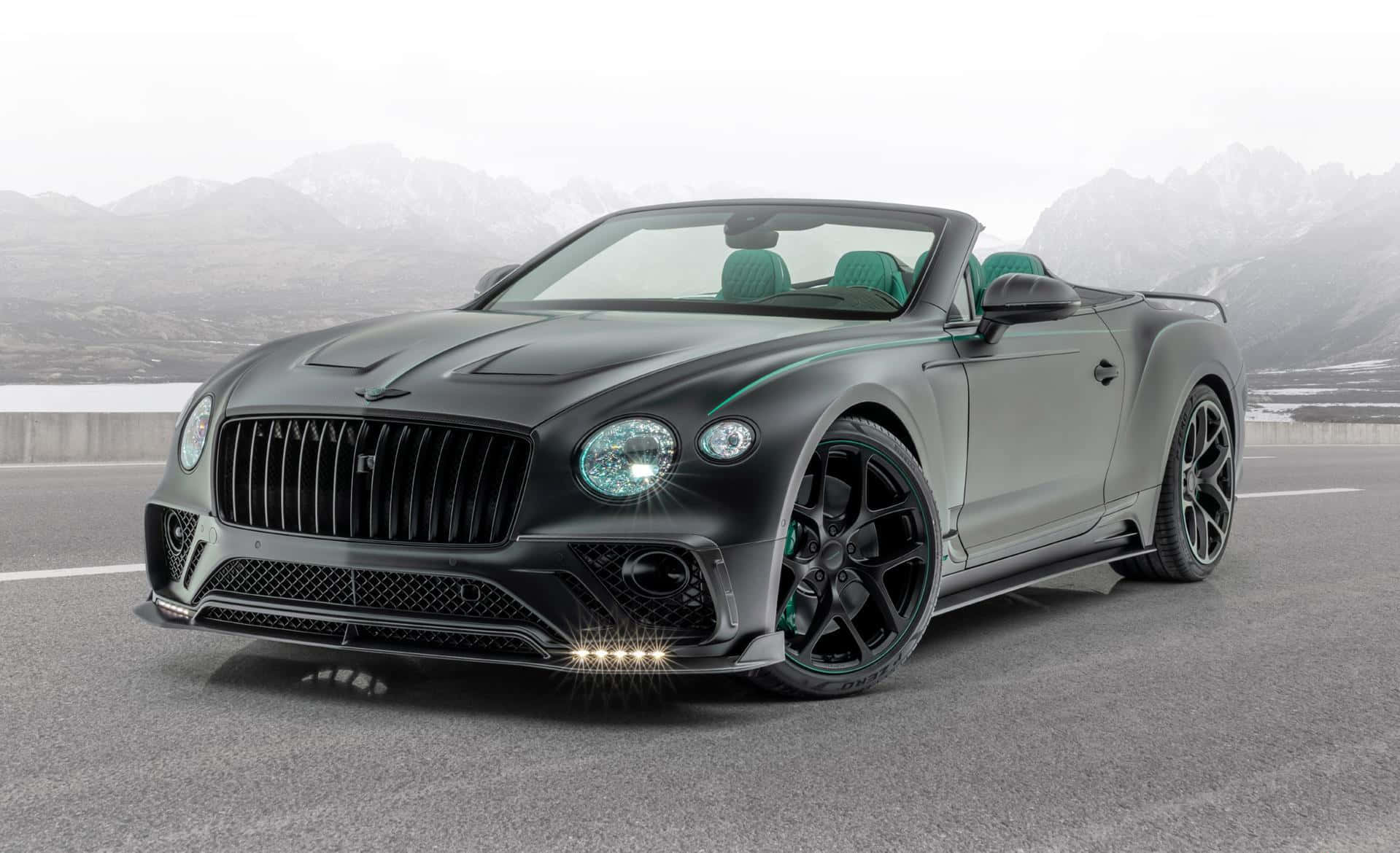 Bentley Continental Gt Convertible 桌布 壁紙 — 一架啞黑色賓利開篷車，綠色內籠，停泊喺路上，背景係積雪嘅山脈。