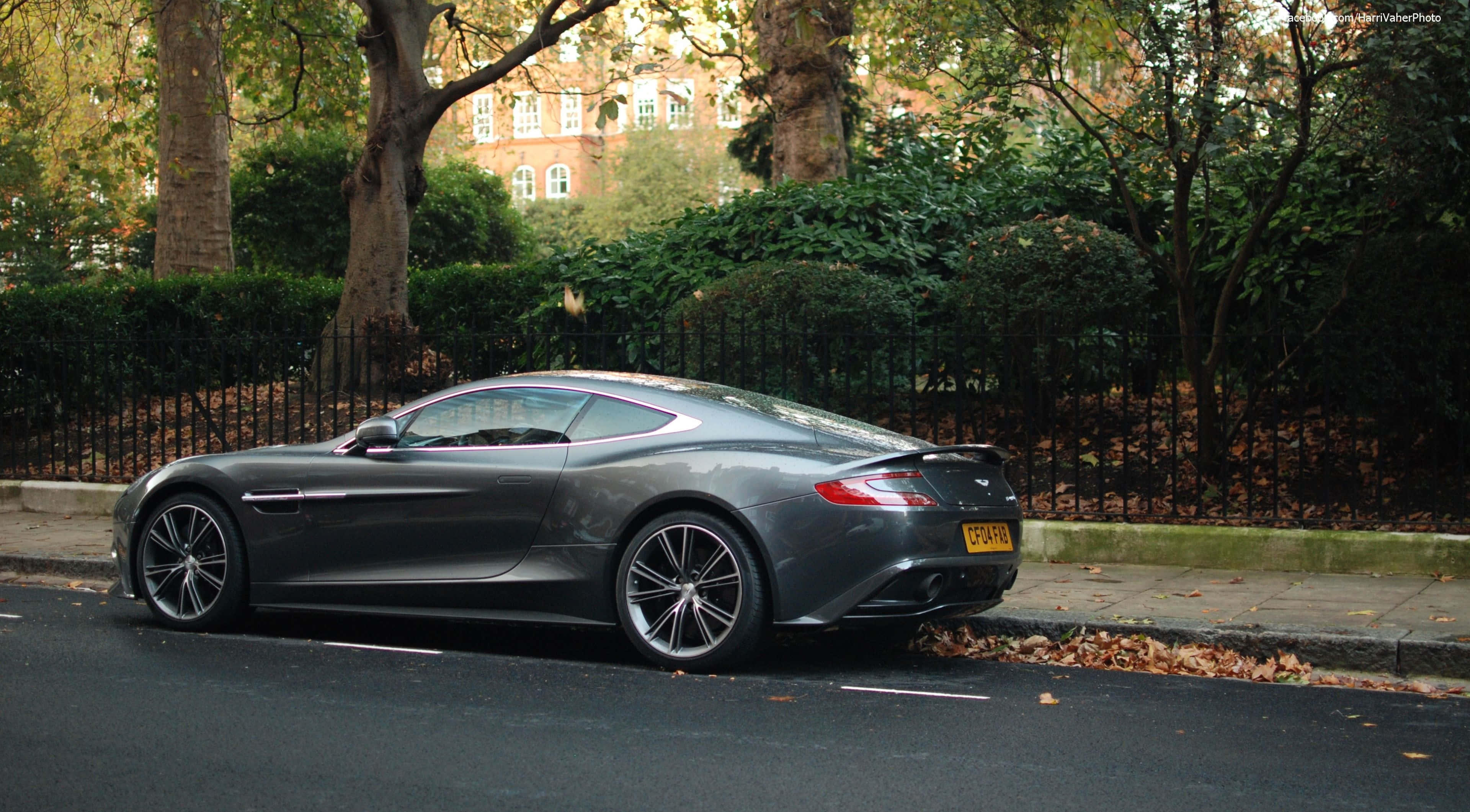 Aston Martin Vanquish 桌布 壁紙 — 一架型格啞灰色Aston Martin Vanquish停泊在樹木林立、落葉滿地的秋日街道上。