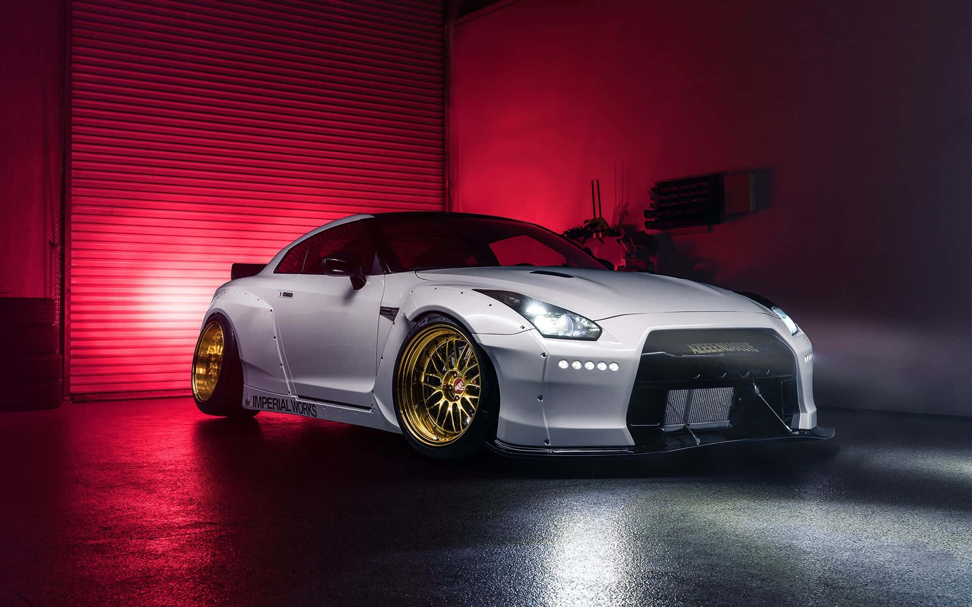 Gtr 桌布 壁紙 — 一架型格白色日產GT-R配金色輪圈，在昏暗車庫中於戲劇性的紅燈下閃耀。