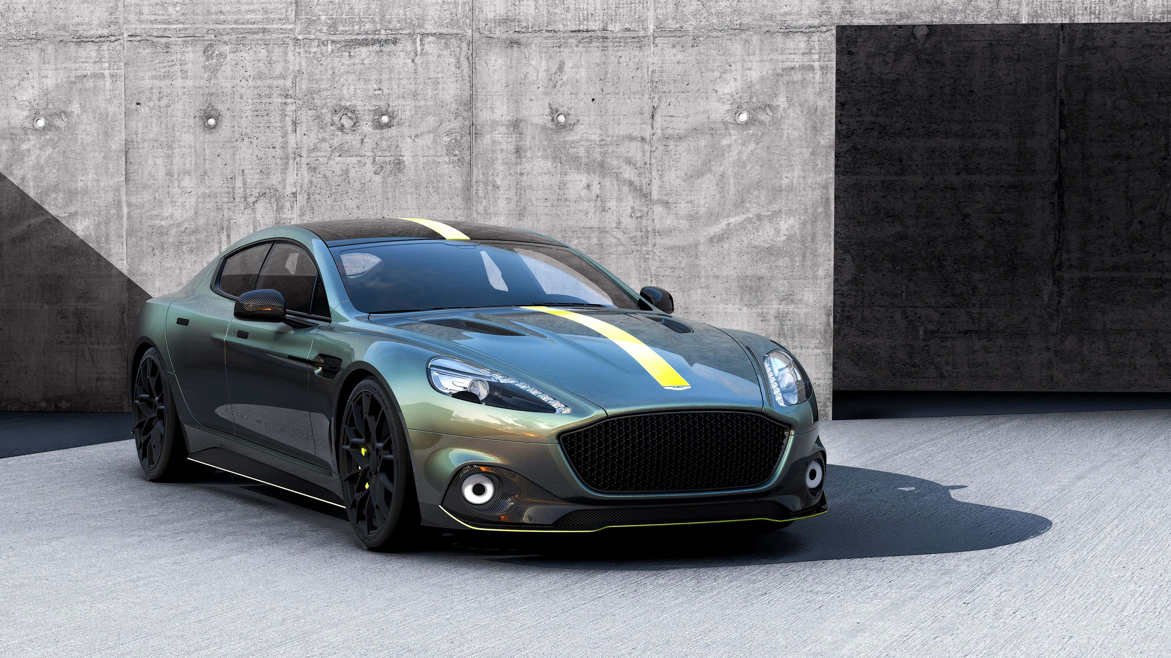Aston Martin Rapide S 桌布 壁紙 — 一架型格綠色Aston Martin，帶有黃色賽車條紋，停泊在紋理混凝土牆前。