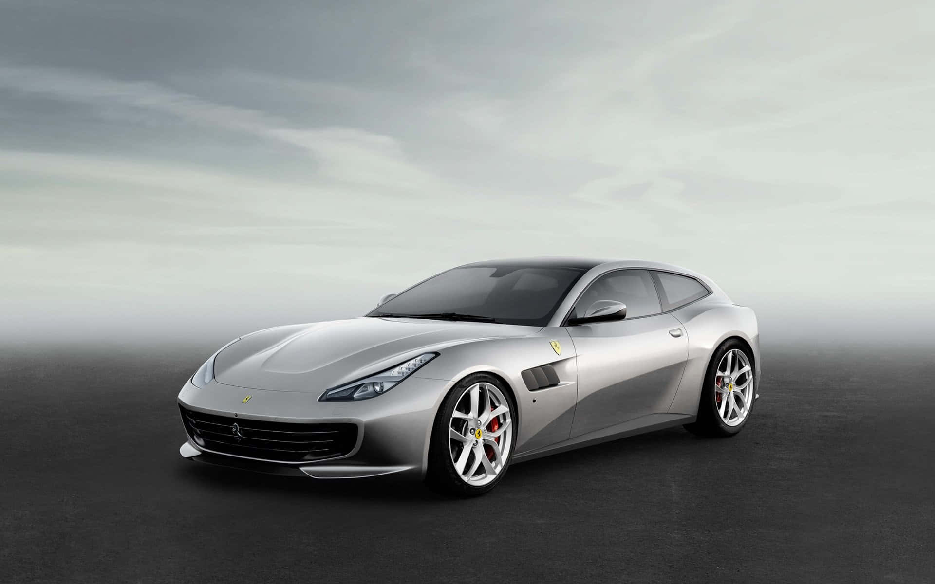 Ferrari Gtc4lusso 桌布 壁紙 — 一架型格銀色法拉利跑車配紅色制動卡鉗，在暗淡灰色天空下停泊在深色表面上。