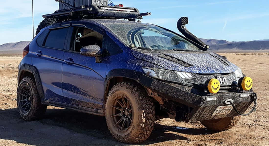 Off-road Car 桌布 壁紙 — 一架堅固的藍色本田SUV覆蓋著泥濘，準備在晴朗藍天下於廣闊沙漠中進行越野駕駛。