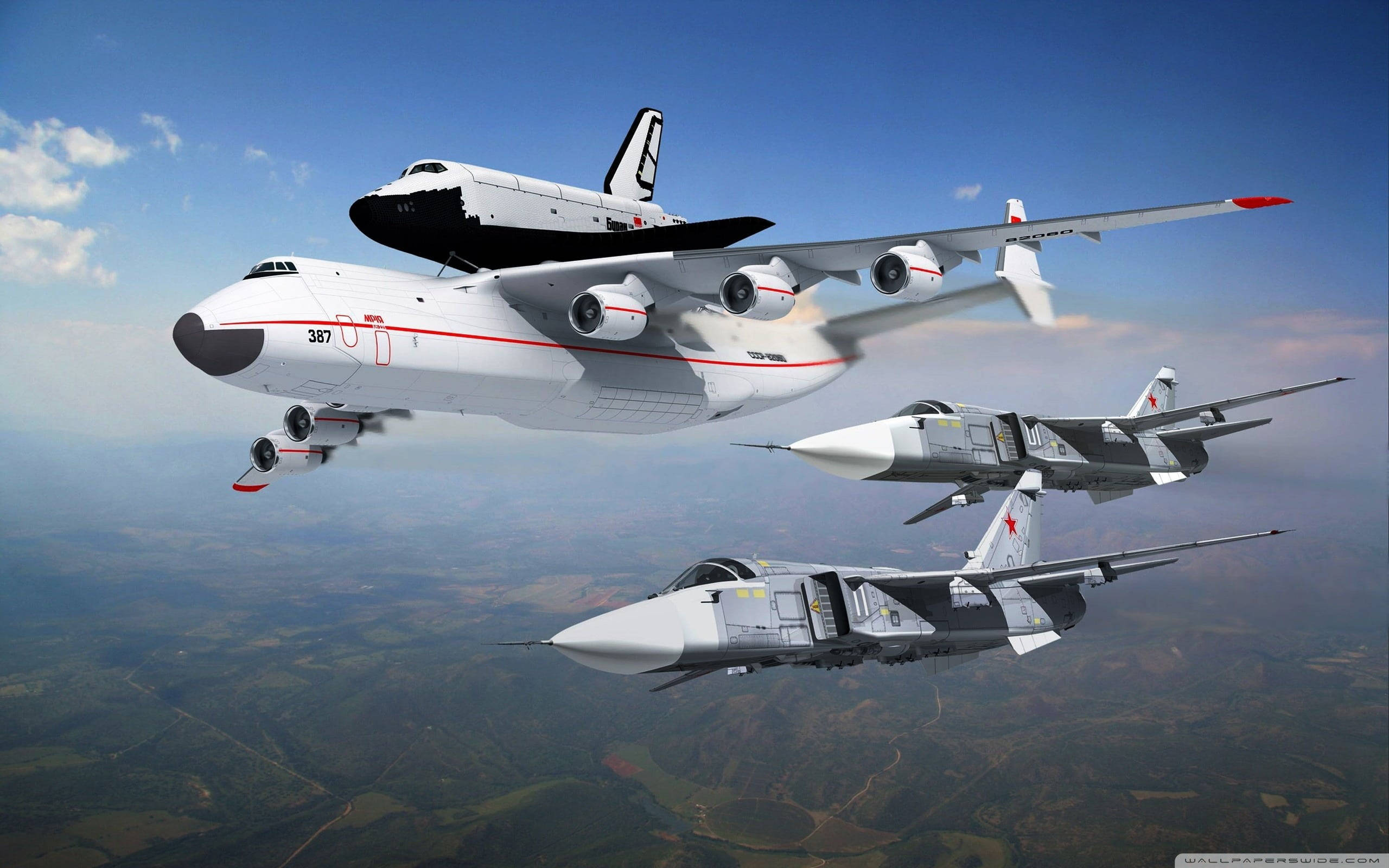 軍事動圖 桌布 壁紙 — 一架大型白色運輸機載著一架太空穿梭機，兩架戰鬥機在綠色景觀上空並排飛行。