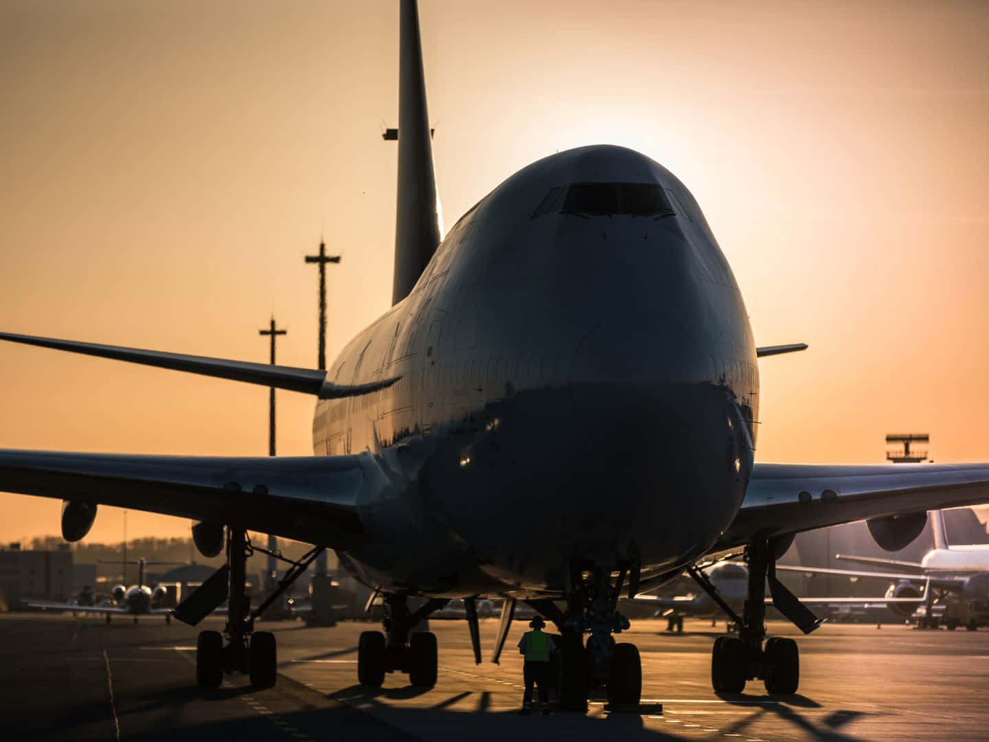 日落時停機坪上的大型飛機及地勤人員