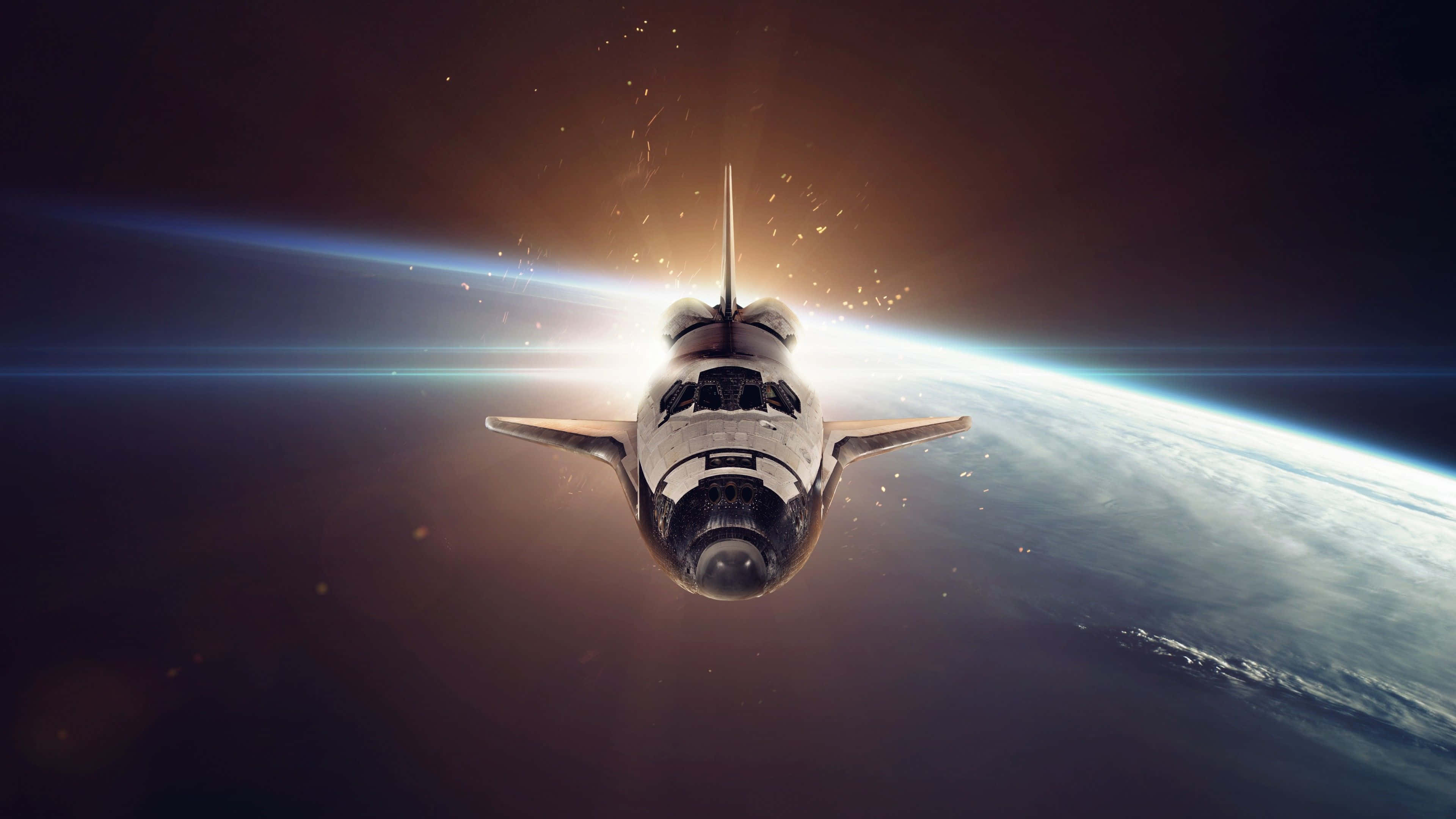太空船 桌布 壁紙 — 一架太空穿梭機在地球彎曲的地平線上空翱翔，燦爛的日出將金色光芒和鏡頭光暈投射到黑暗的宇宙中。