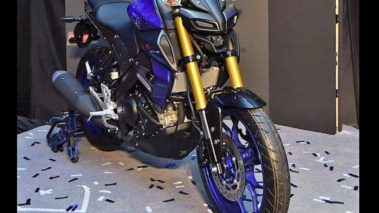 yamaha mt 15 桌布 壁紙 — 一架帶有紫色和金色點綴的時尚運動電單車，停放在工作室內鋪滿五彩紙屑的地板上。
