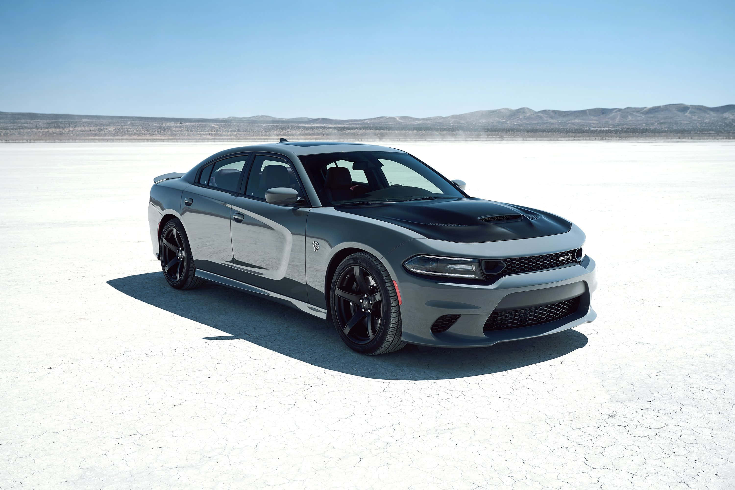 Dodge Charger 桌布 壁紙 — 一架帶有黑色點綴的時尚銀色道奇Charger，在晴朗藍天下矗立於廣闊的龜裂鹽灘上。