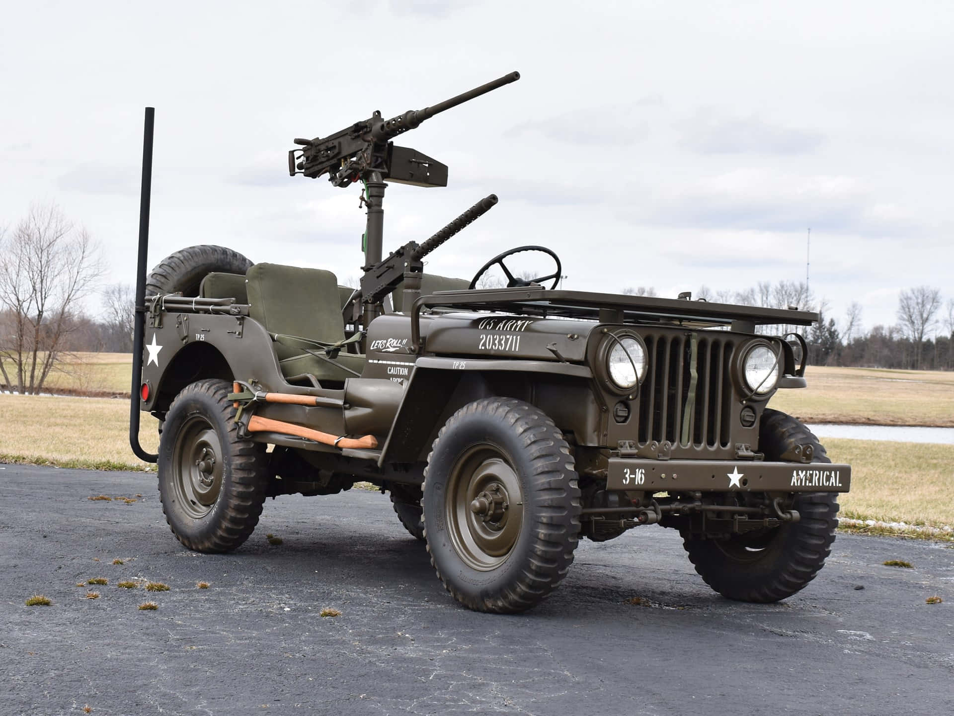 Jeep Willys 桌布 壁紙 — 一架復古橄欖綠軍用吉普車，裝有機槍，停在瀝青路面上，背景是陰天。
