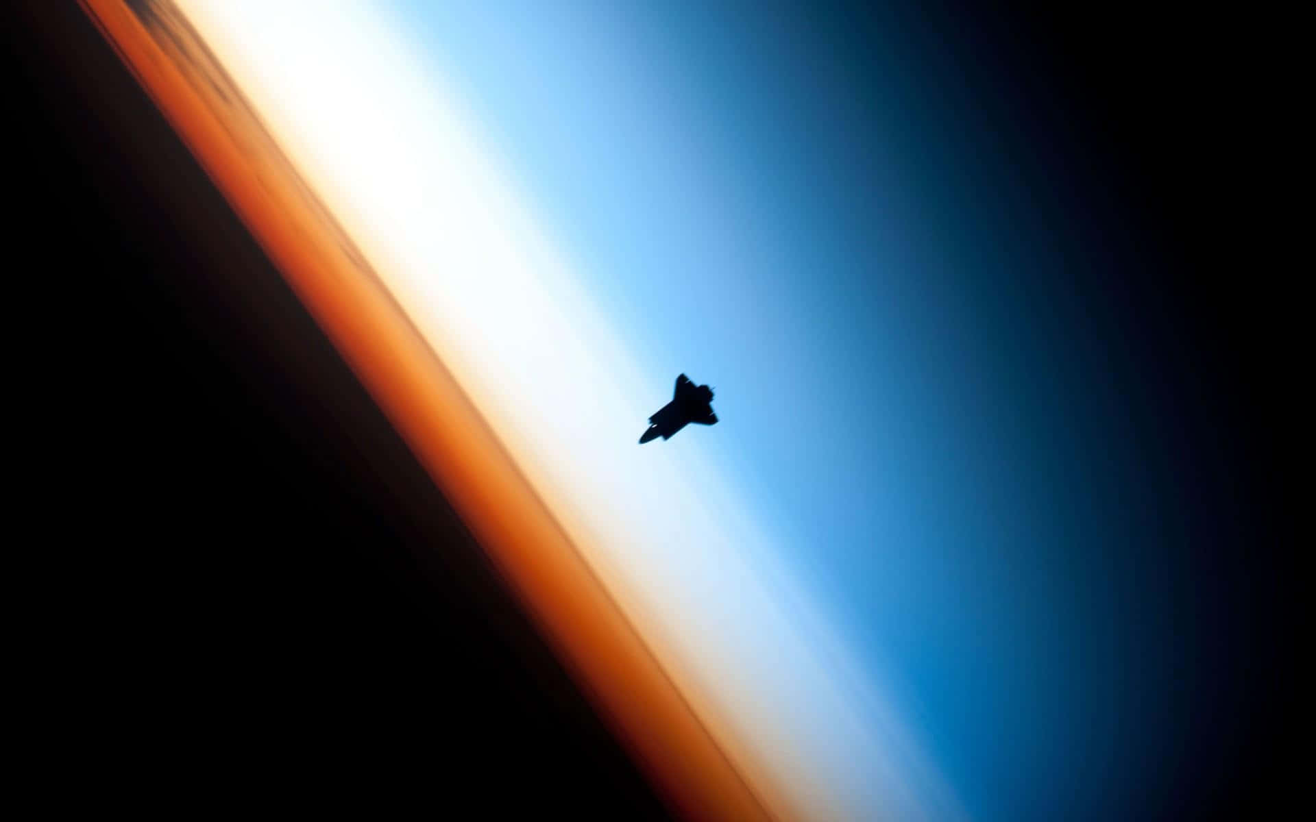 Space Mission 桌布 壁紙 — 一架戰鬥機的剪影在太空中的地球鮮豔彎曲地平線前翱翔，帶有橙色和藍色漸變。