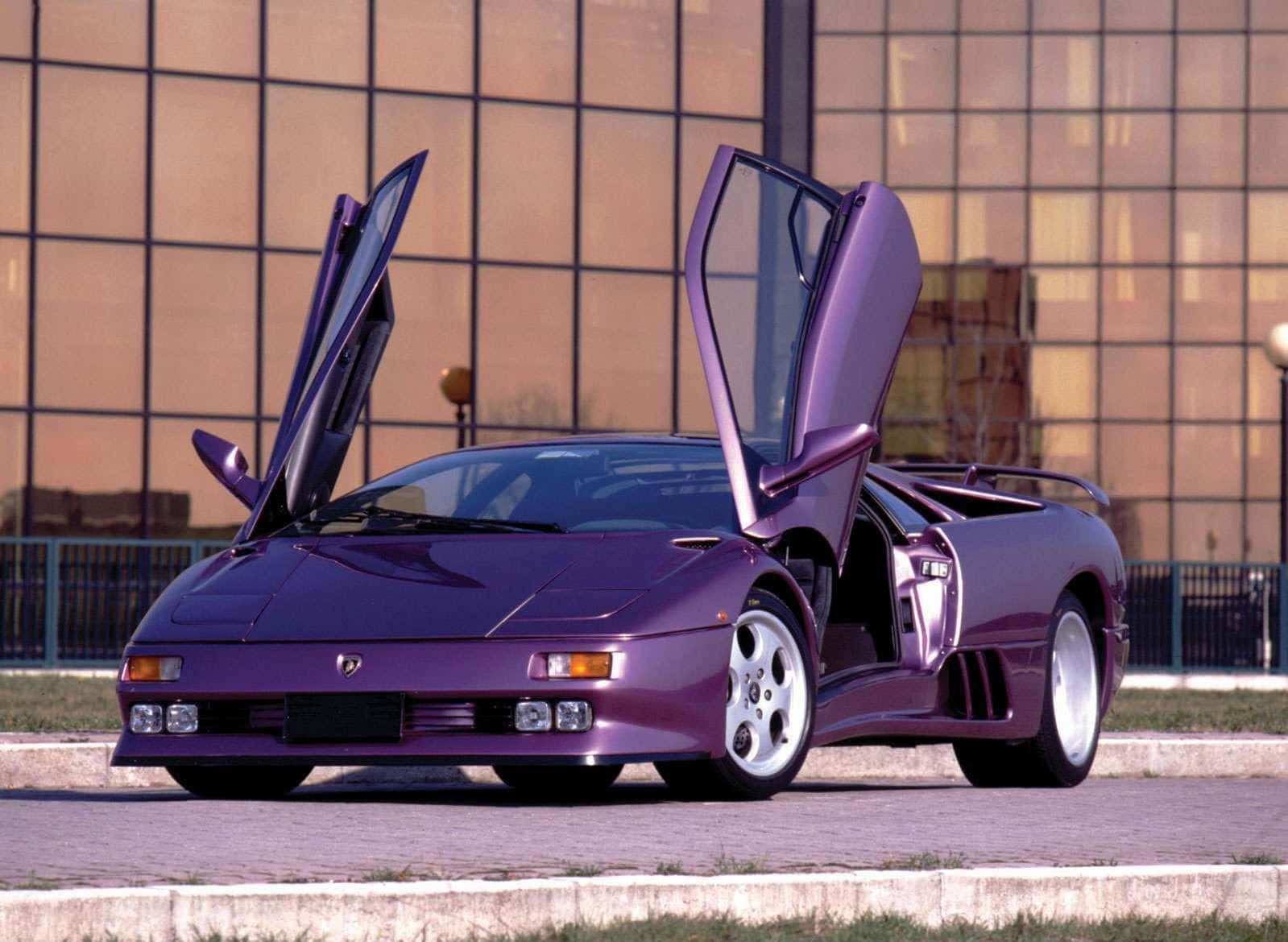 Lamborghini Diablo 桌布 壁紙 — 一架搶眼的紫色林寶堅尼 Diablo 打開鷗翼車門，自豪地停泊在現代玻璃建築前的鋪砌區域。