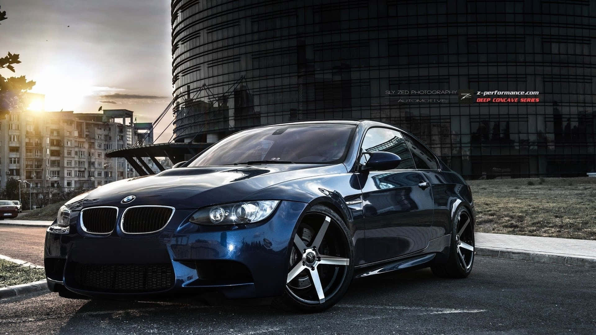 2020 BMW 4 Series Gran Coupe 壁紙 — 一架時尚深藍色BMW跑車停泊在日落時分的城市街道上，背後有一座現代玻璃建築。