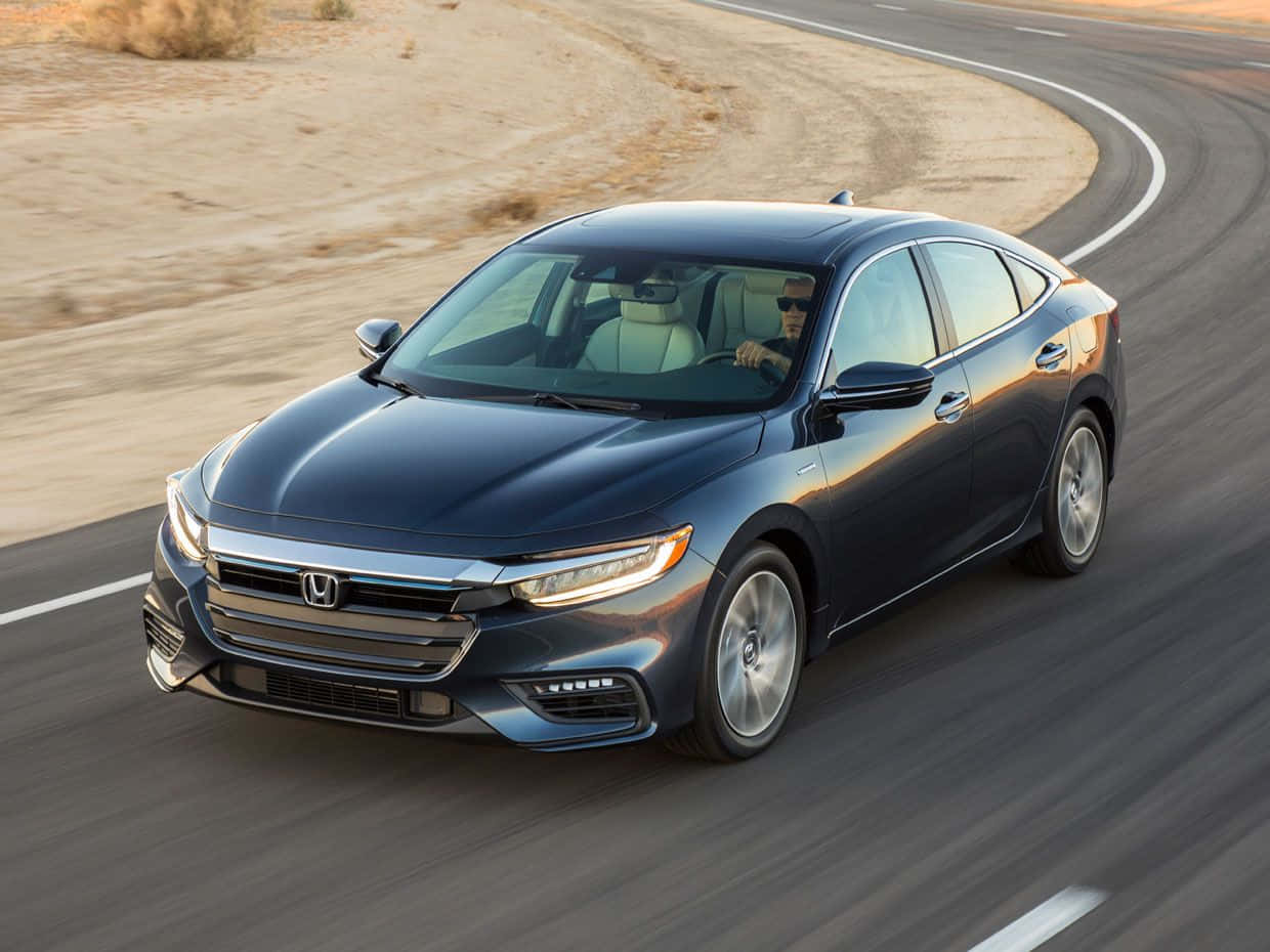 Honda Insight 桌布 壁紙 — 一架時尚深藍色本田房車在溫暖金色陽光下，沿著蜿蜒的沙漠高速公路飛馳。