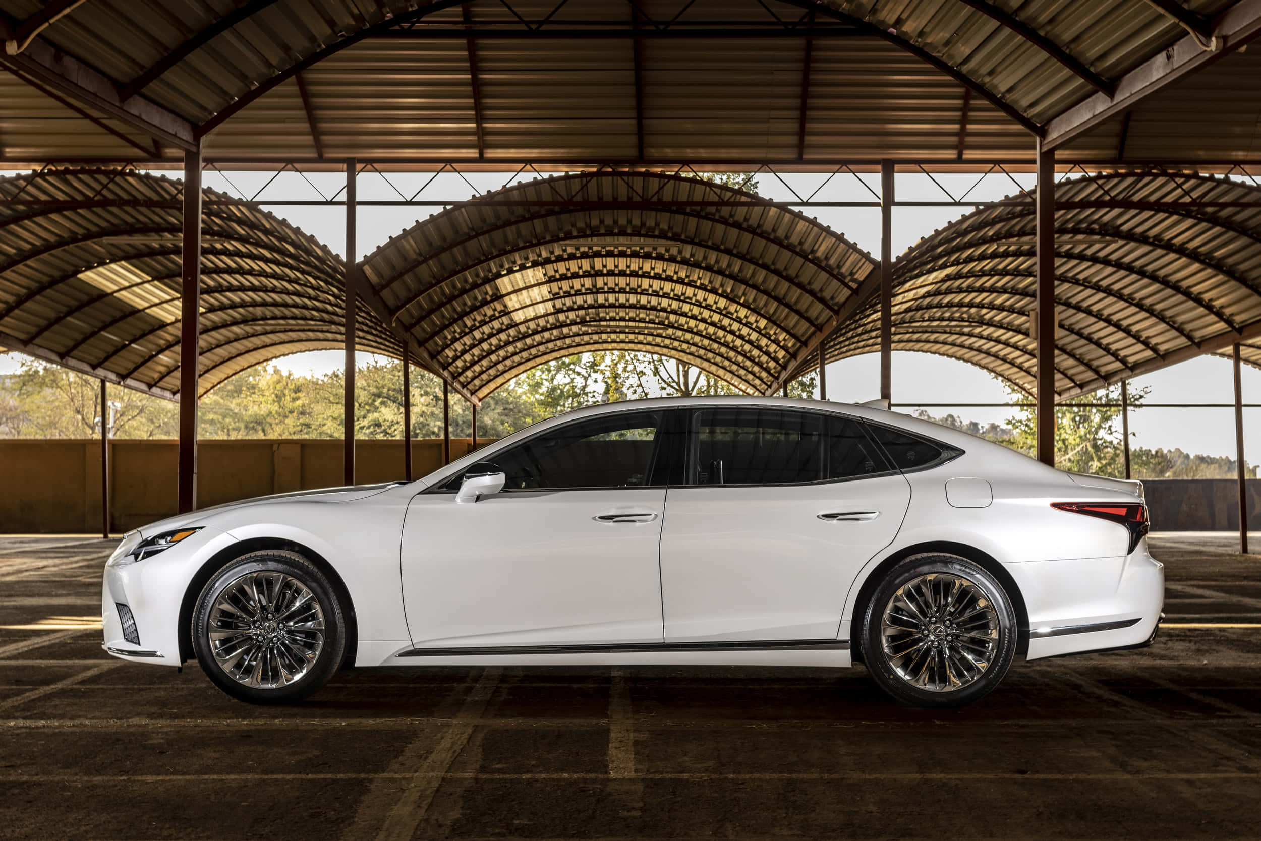 Lexus Ls 500 桌布 壁紙 — 一架時尚白色豪華轎車停泊在彎曲金屬屋頂下，陽光穿透灑落。