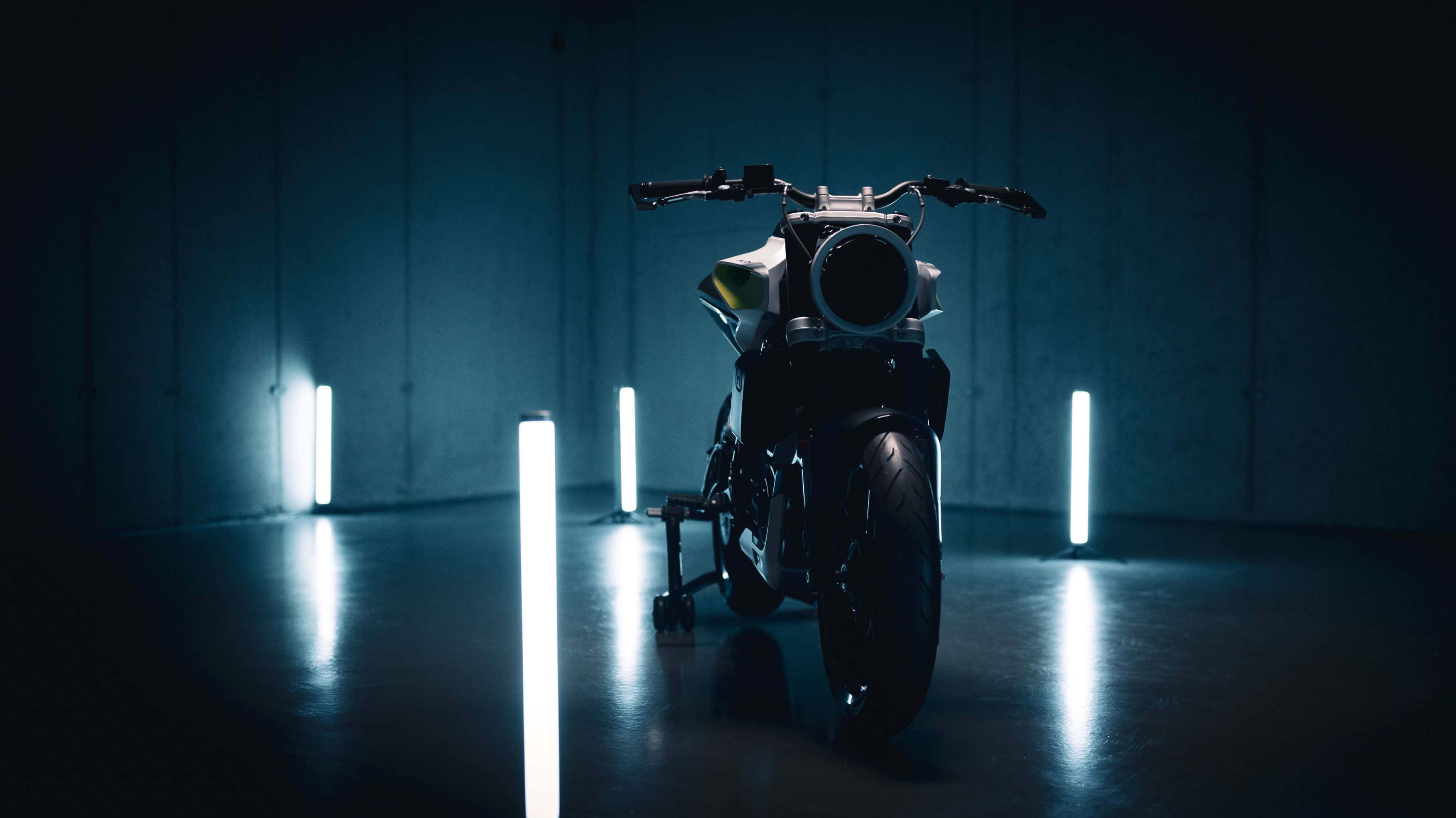 Electric Bike 桌布 壁紙 — 一架時尚的未來電單車位於昏暗的混凝土房間中央，由垂直發光的藍色燈條照亮。