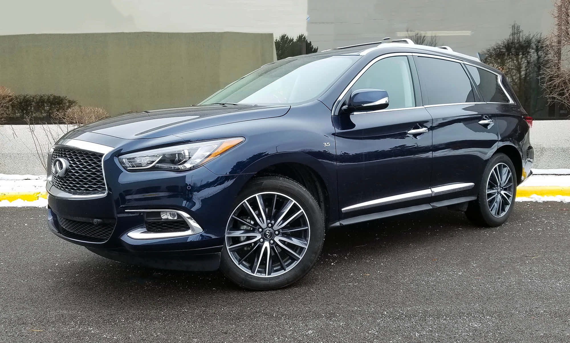 Infiniti Qx60 桌布 壁紙 — 一架時尚的深藍色 Infiniti QX60 SUV 停在瀝青路上，背景有雪堆和光禿禿的樹木。