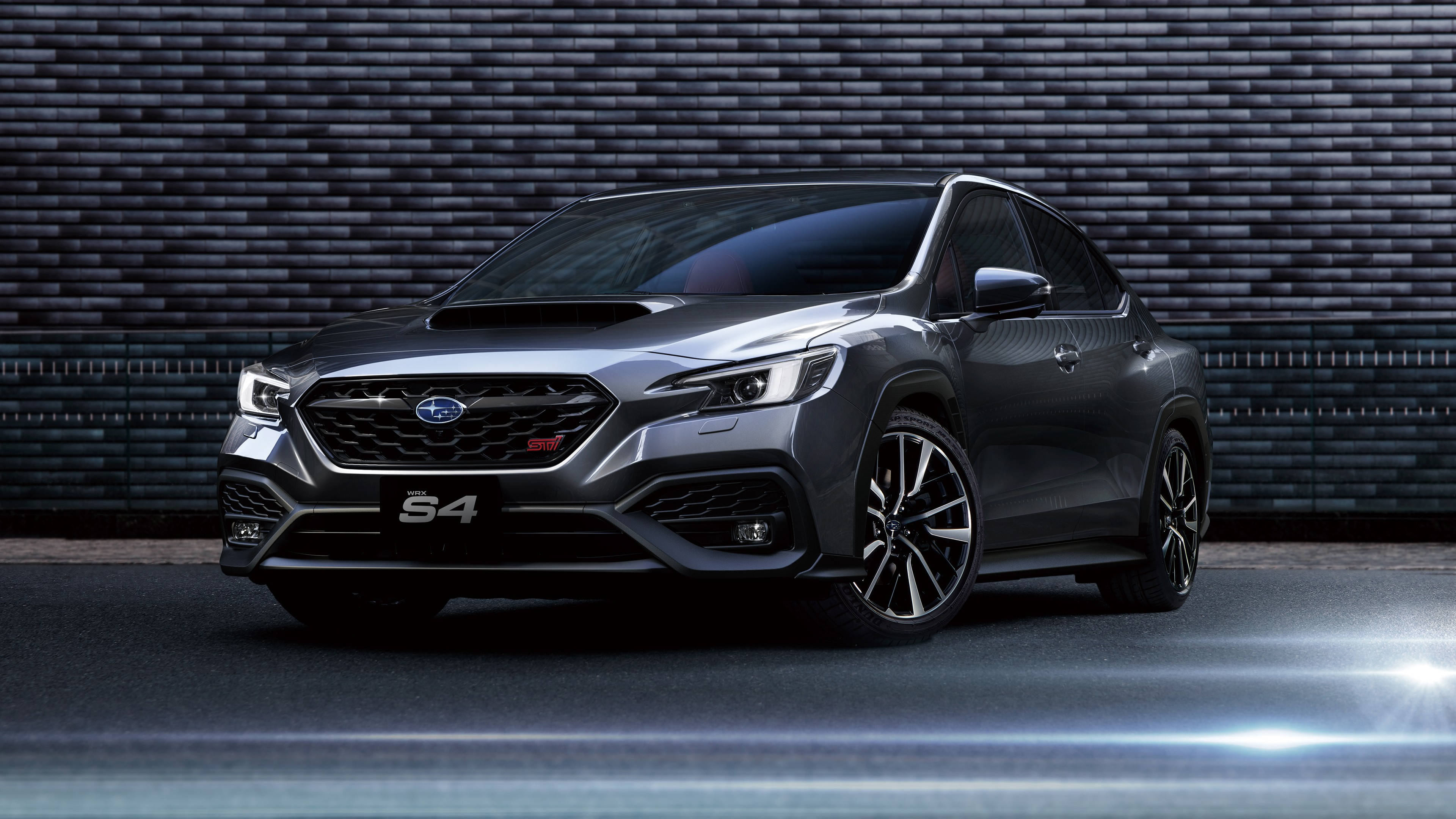 subaru 桌布 壁紙 — 一架時尚的灰色 Subaru S4 性能 SUV 在戲劇性的工作室燈光下，停靠在深色紋理磚牆前。