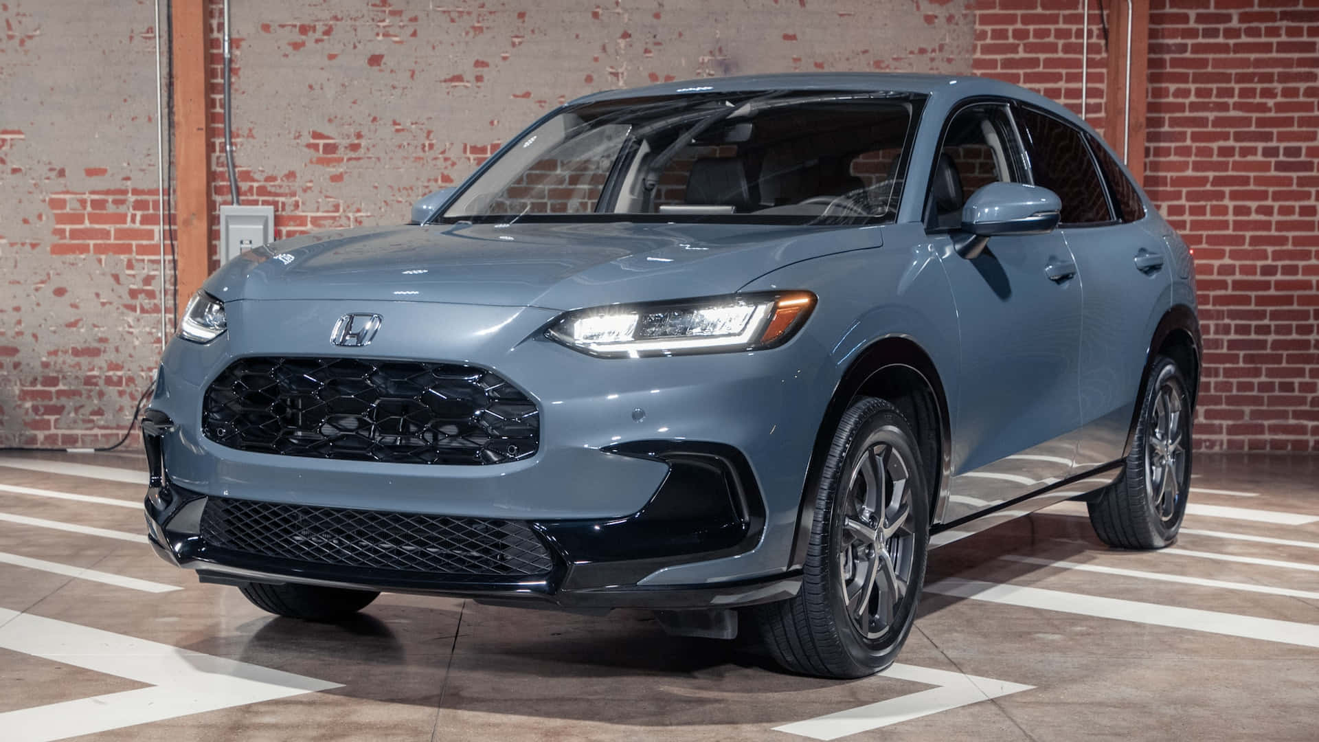 Honda Hr-v 桌布 壁紙 — 一架時尚的灰色本田SUV停放在室內，靠著一面風化的磚牆，地面有白色標記。