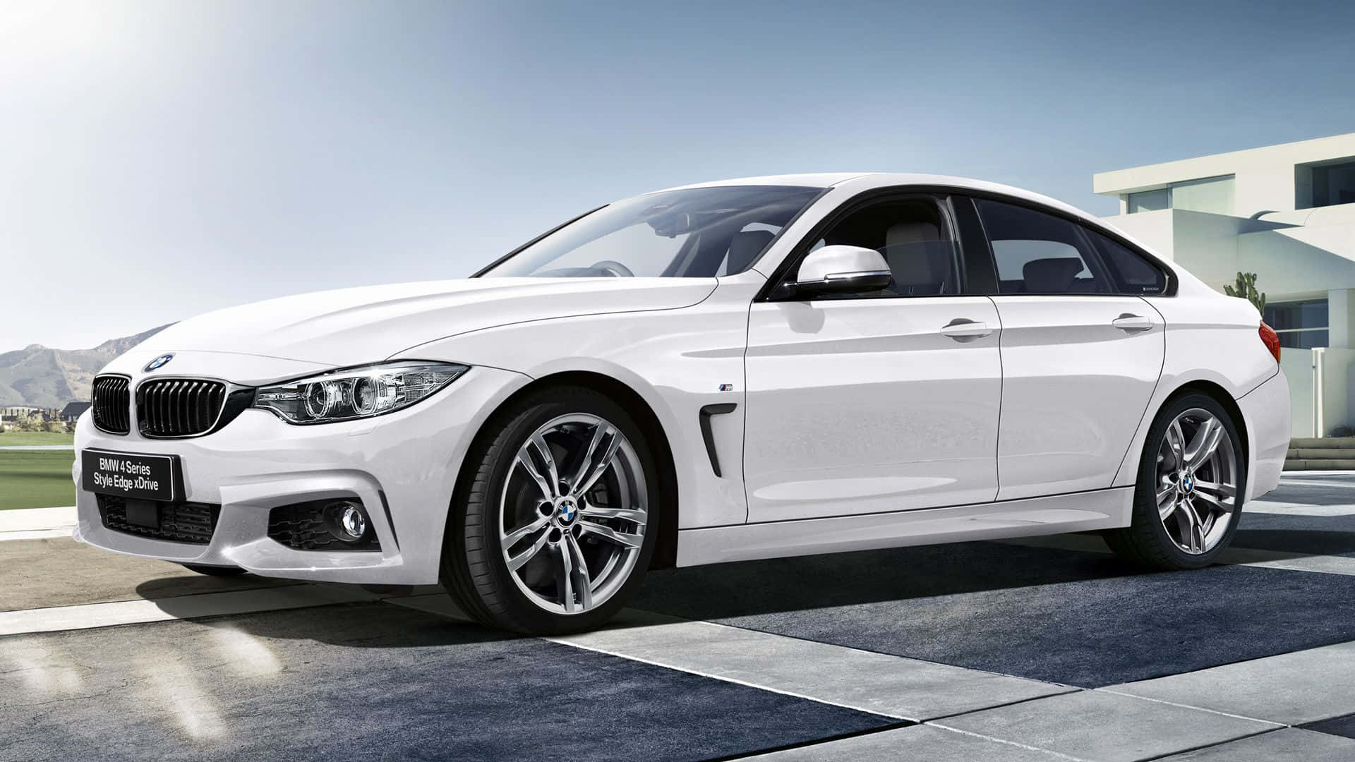 Bmw 4 Series 桌布 壁紙 — 一架時尚的白色BMW 4系轎跑車停泊在現代瓷磚車道上，背景是山脈和晴朗的藍天。