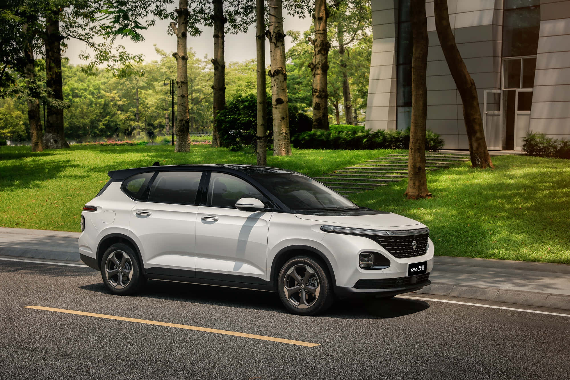 Baojun 桌布 壁紙 — 一架時尚的白色SUV停泊在綠樹成蔭的街道上，旁邊是一座現代建築，周圍有茂密的綠色草地。