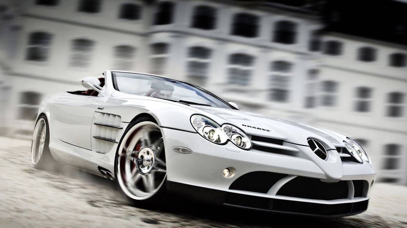 Sports Car 桌布 壁紙 — 一架時尚的白色平治 SLR 麥拿侖開篷跑車在塵土飛揚的道路上，駛過一座模糊的古典建築。
