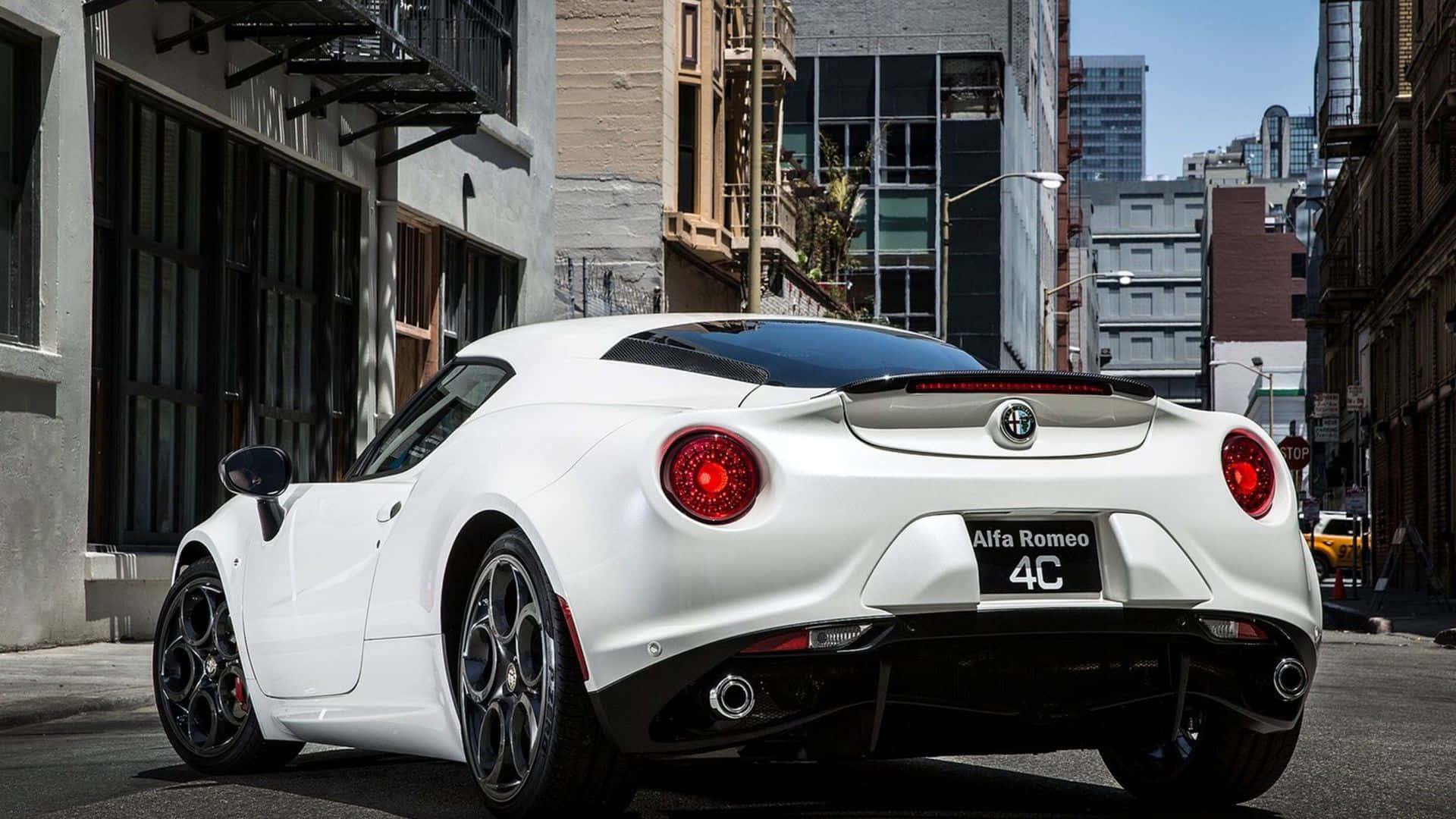 Alfa Romeo 4c 桌布 壁紙 — 一架時尚的白色愛快羅密歐4C跑車停泊在陽光明媚的城市街道上，背景是高樓大廈和防火梯。