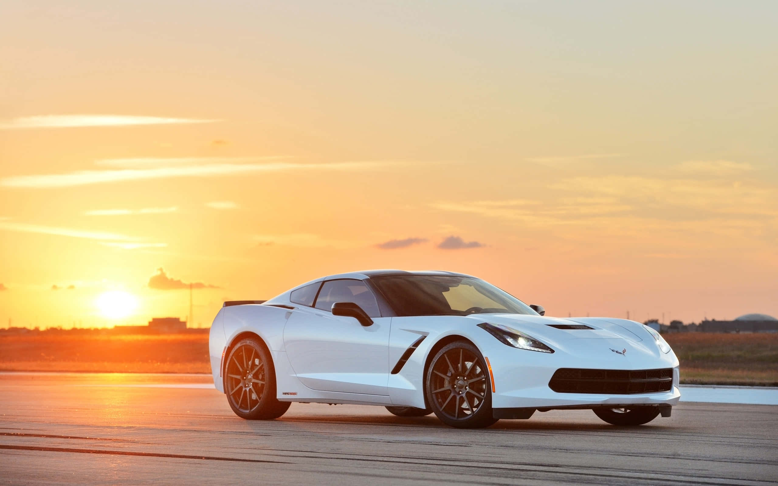 Chevrolet Corvette Stingray 桌布 壁紙 — 一架時尚的白色跑車在跑道上滑行，夕陽在火紅的橙色天空中落下。