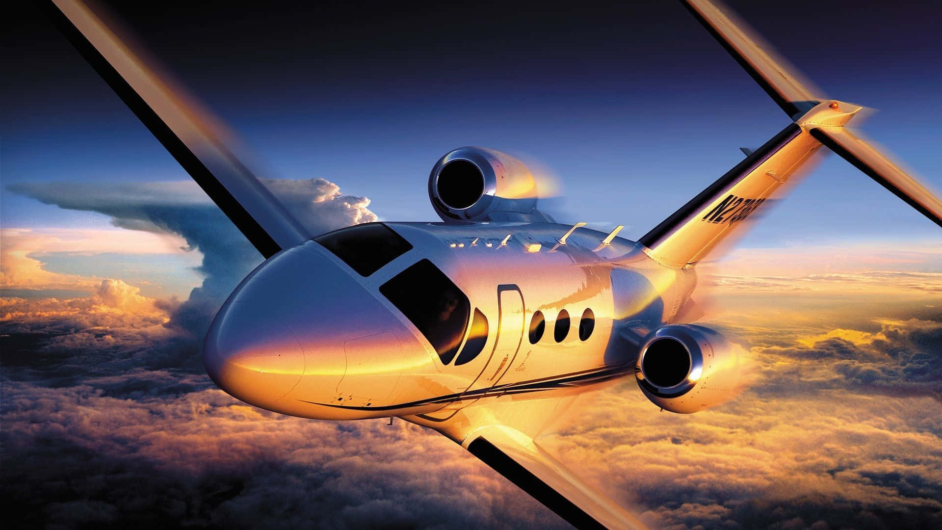 Jet 桌布 壁紙 — 一架時尚的私人飛機在日落時分翱翔於金色雲層之上，天空呈現鮮豔的橙色和藍色色調。