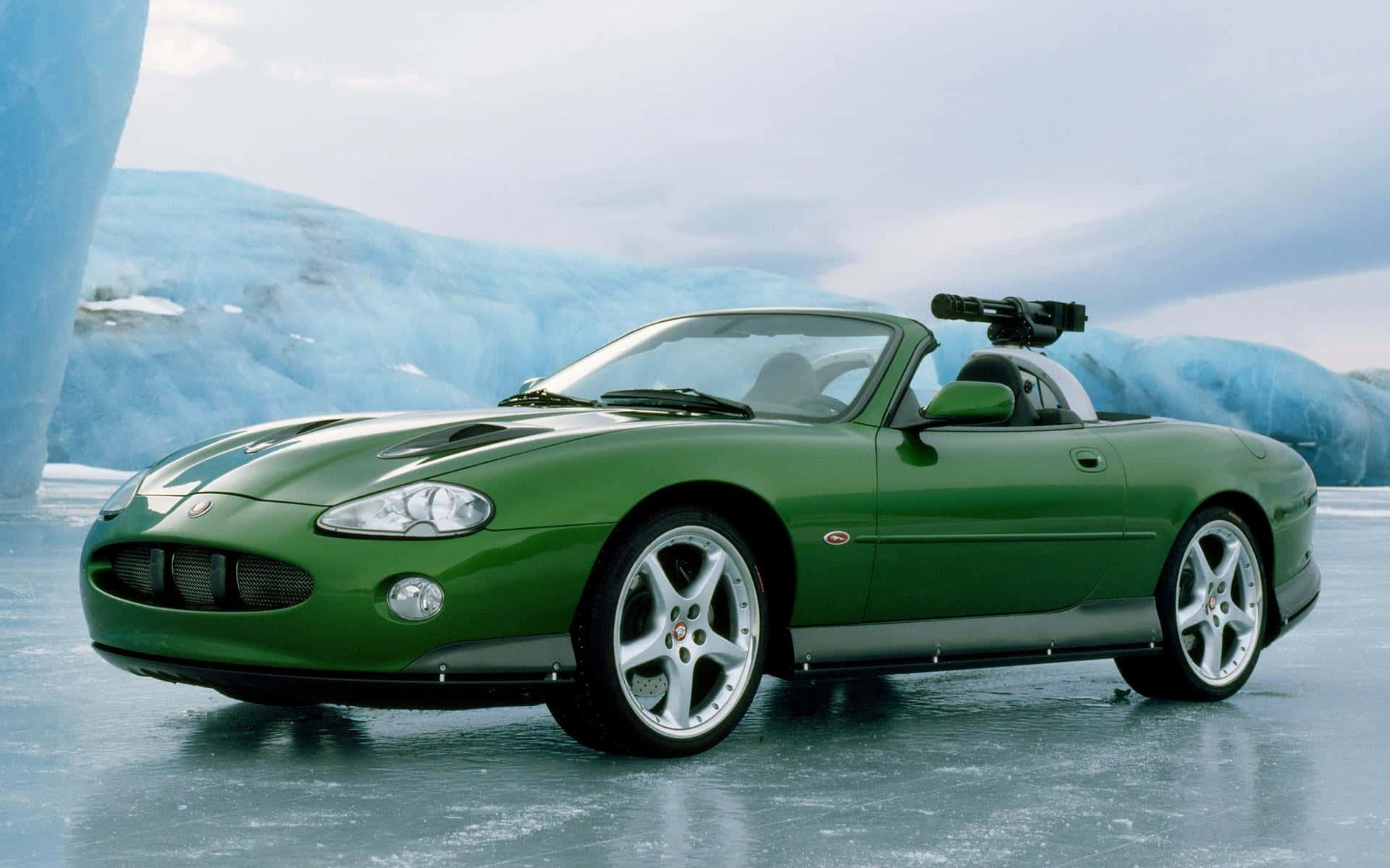 Jaguar Xkr 桌布 壁紙 — 一架時尚的綠色開篷跑車停泊在冰天雪地上，背景是巨大的藍色冰山。