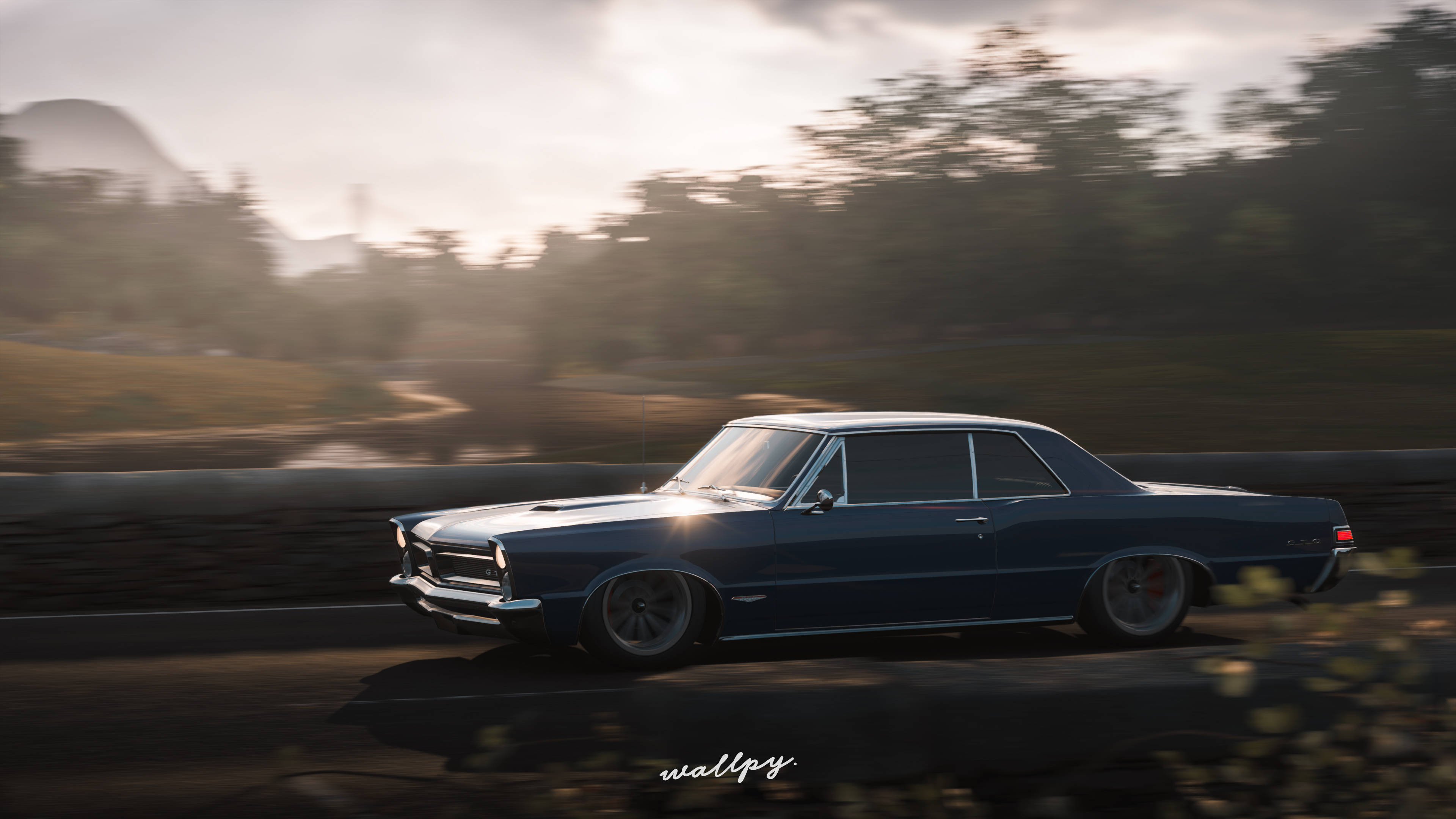 遊戲 桌布 壁紙 — 一架時尚的藍色經典肌肉車在黃金時段沿著蜿蜒的道路飛馳，背景是模糊的樹木和山丘。