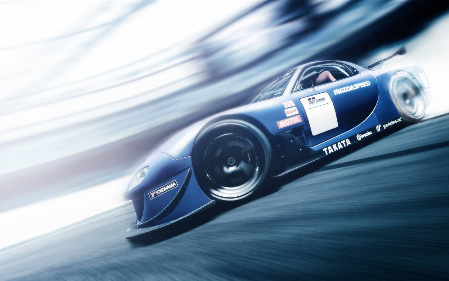 Mazda 桌布 壁紙 — 一架時尚的藍色賽車在賽道上疾馳，伴隨動態模糊效果，傳達極致速度與力量。