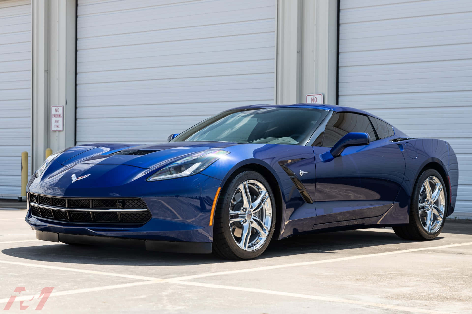 Chevrolet Corvette Stingray 桌布 壁紙 — 一架時尚的藍色雪佛蘭克爾維特跑車在陽光明媚的日子停放在白色工業車庫門前。