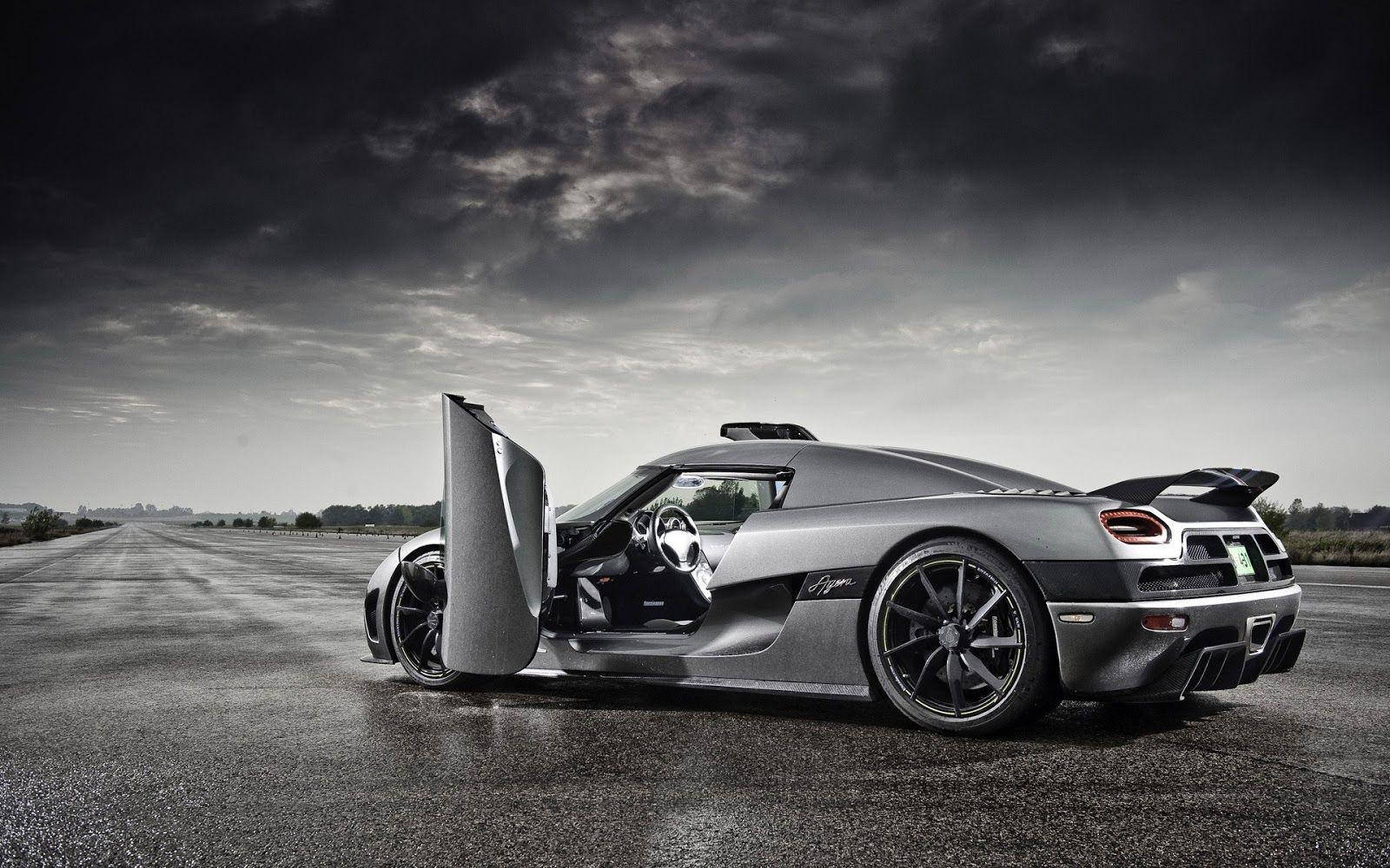 黑白 桌布 壁紙 — 一架時尚的銀色Koenigsegg Agera停在空蕩的瀝青路上，剪刀門打開，背景是戲劇性的多雲天空。