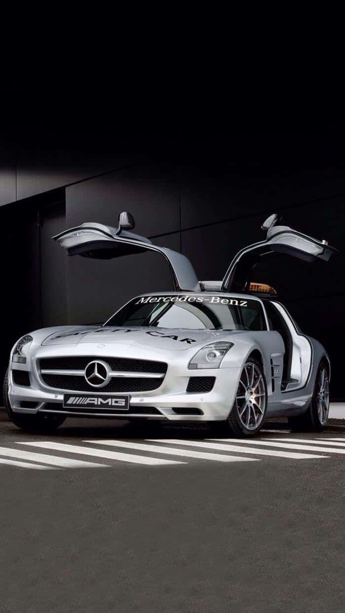 Safety Car 桌布 壁紙 — 一架時尚的銀色平治SLS AMG安全車，鷗翼車門打開，停在有白色標線的深色瀝青路上，在戲劇性的工作室燈光下。